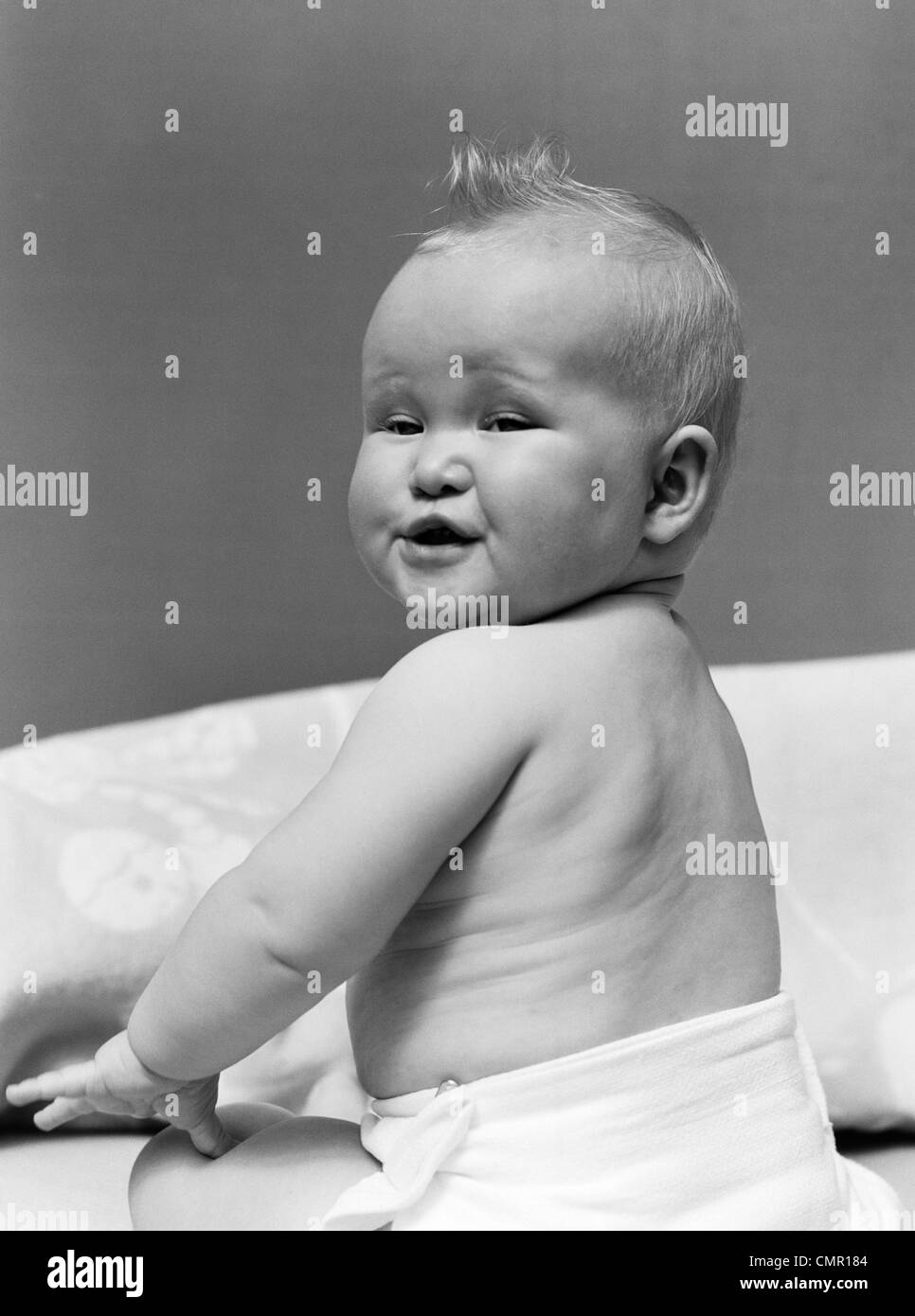 1940s BABY nel pannolino guardando indietro sulla spalla con la divertente espressione facciale Foto Stock