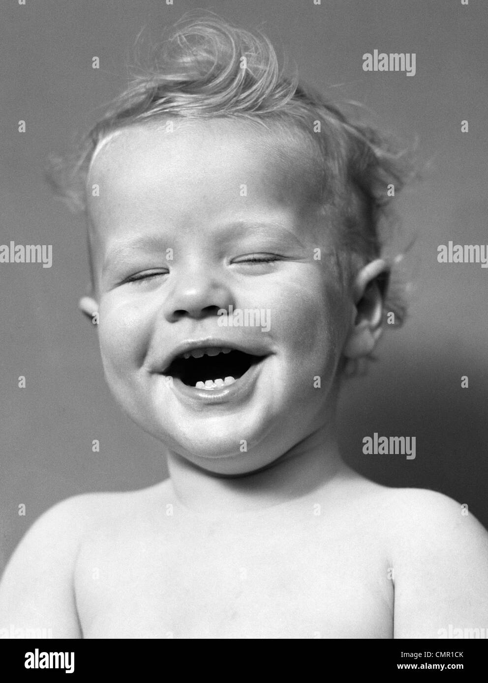 1940s ritratto bambino con disordinati capelli a ridere con gli occhi chiusi Foto Stock
