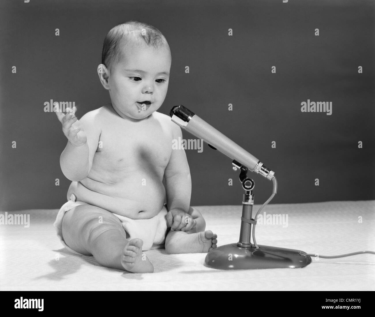 Anni sessanta BABY nel pannolino parlando nel microfono Foto Stock