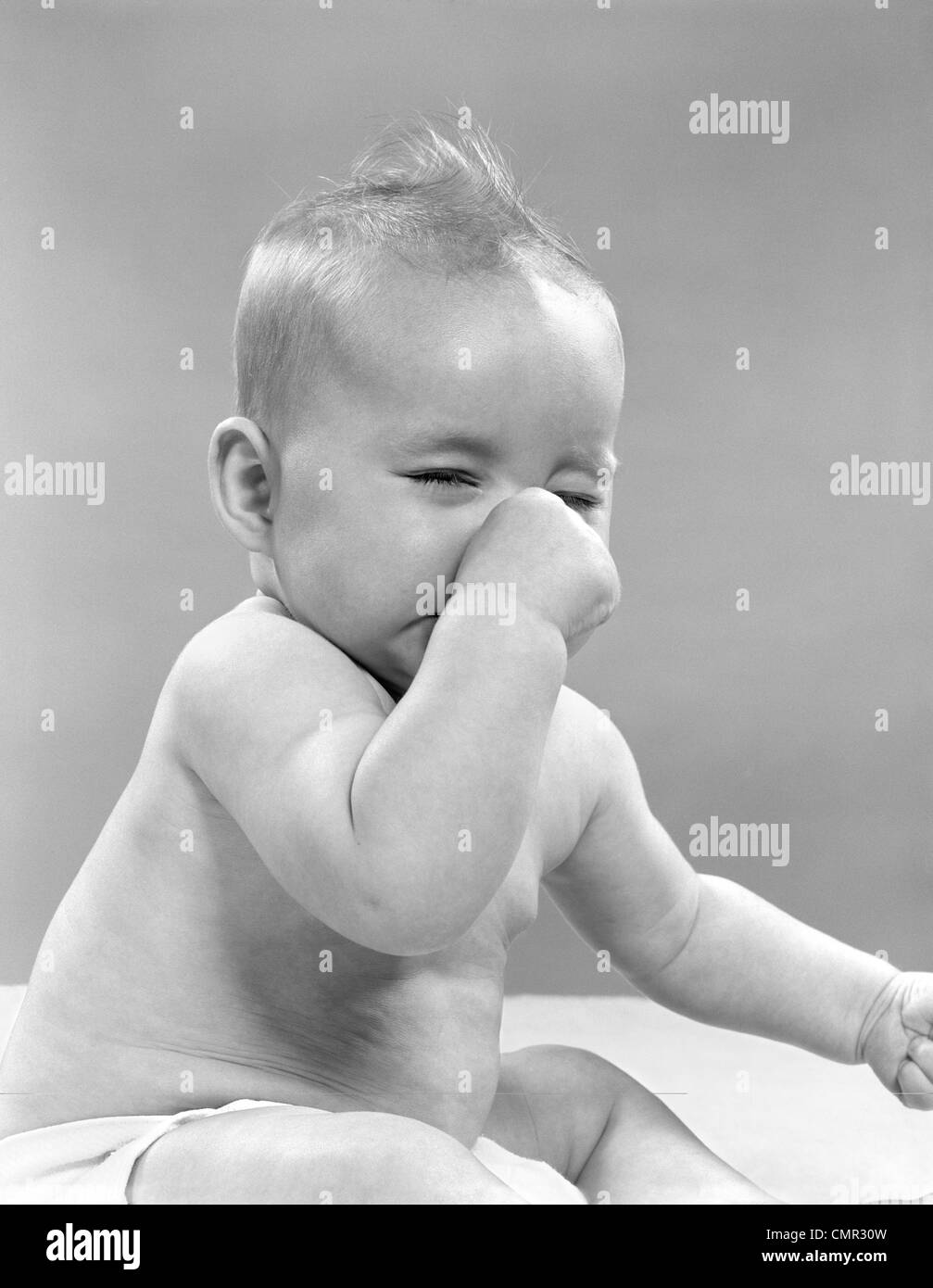 Anni Cinquanta il bambino con gli occhi chiusi tenendo il naso Foto Stock