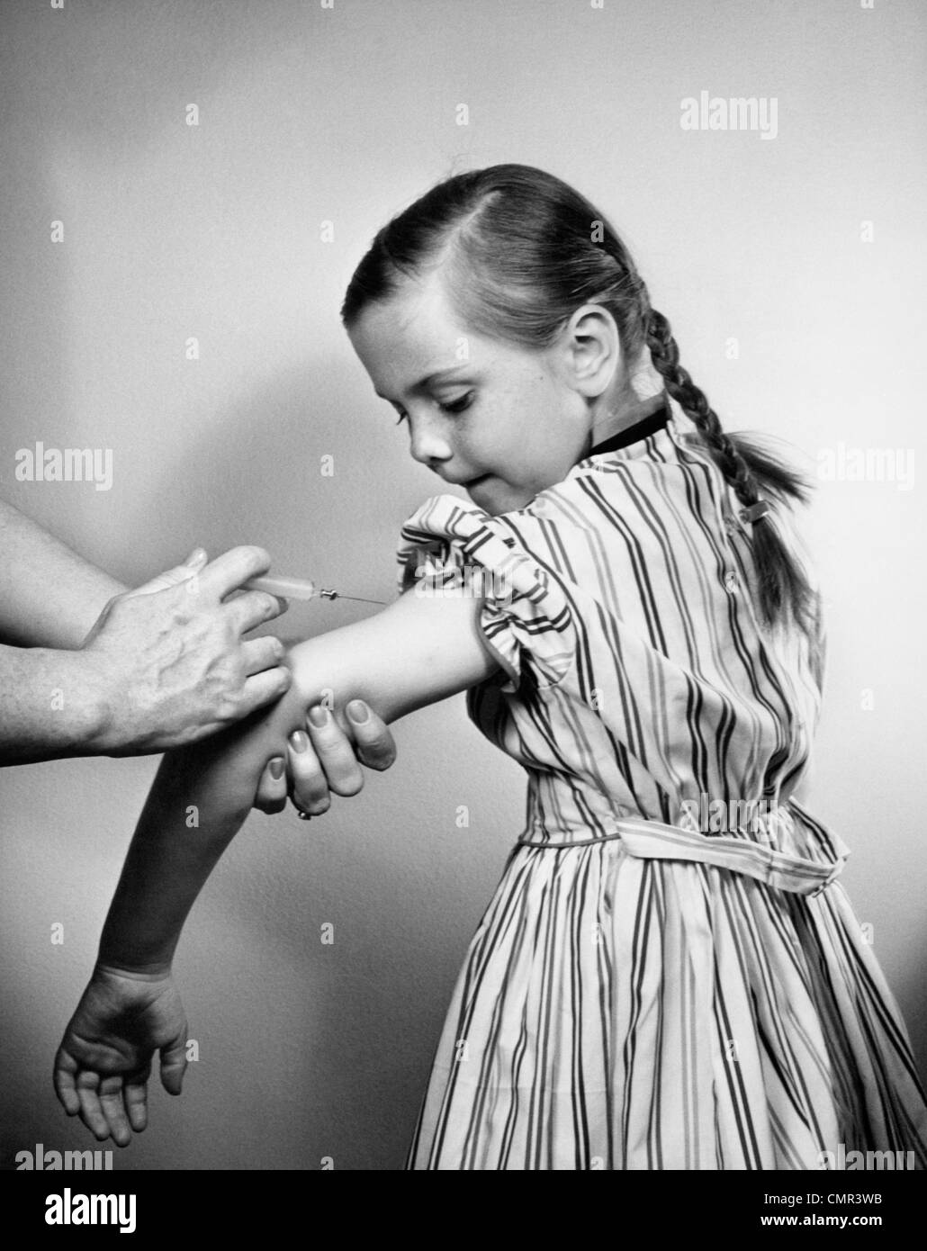 Anni Cinquanta giovane ragazza ottenendo la vaccinazione girato nel suo braccio Foto Stock