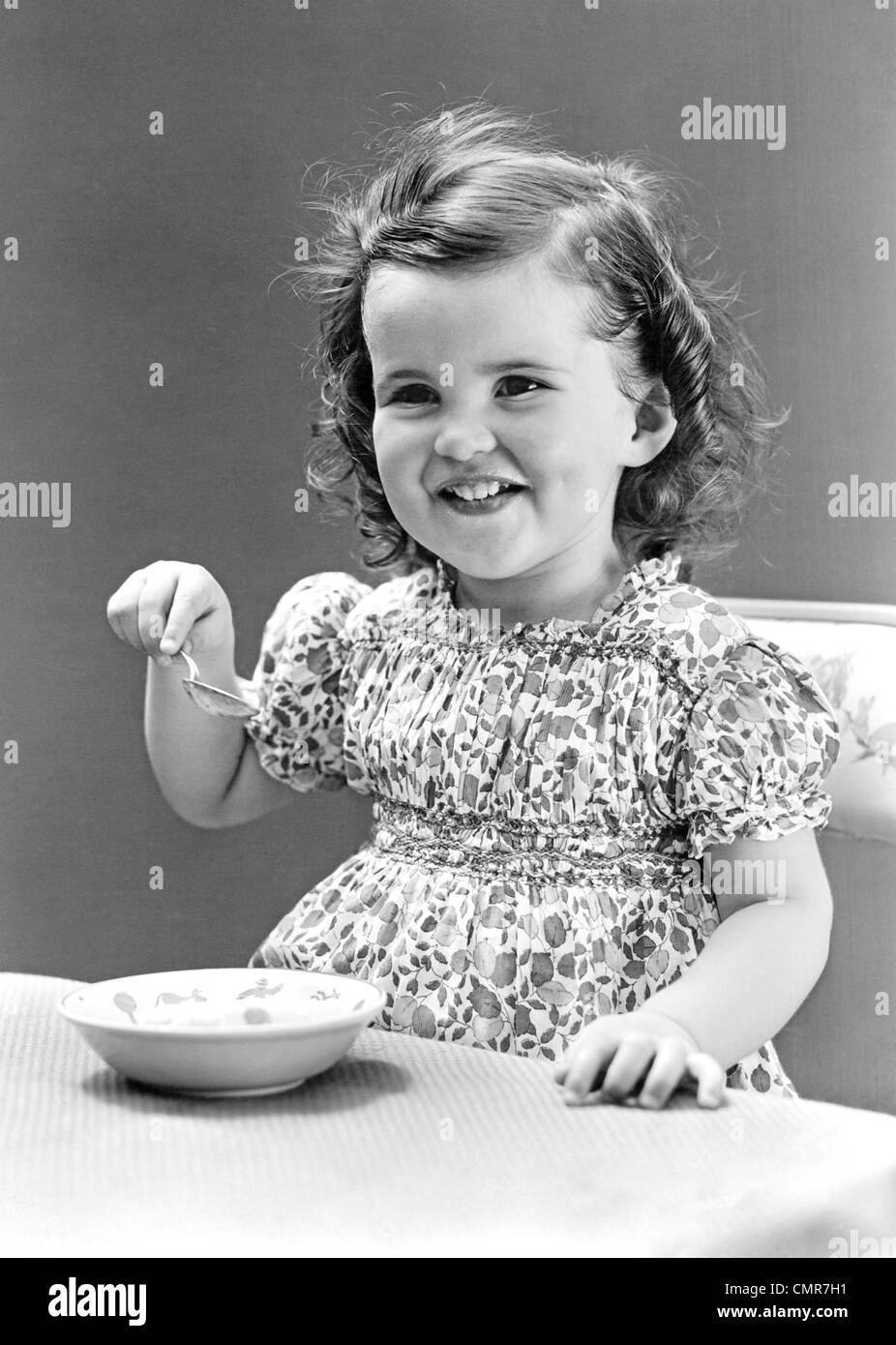 1940s 1930 sorridente bambina di mangiare la coppa di gelato Foto Stock