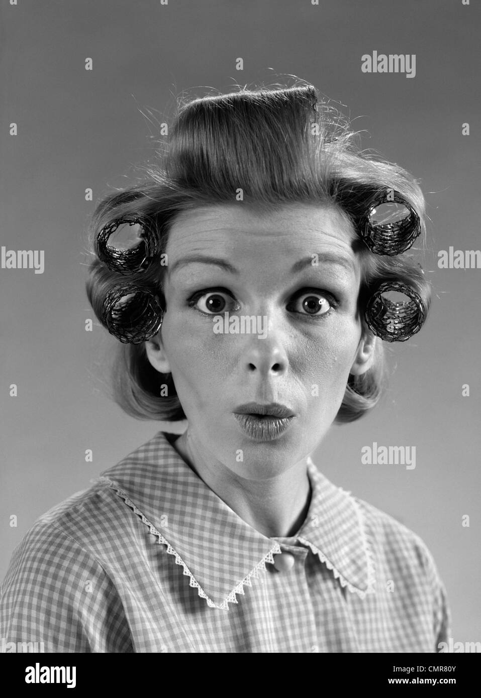 Anni sessanta ritratto donna con capelli rulli IN OCCHI CON sorpresa Foto Stock