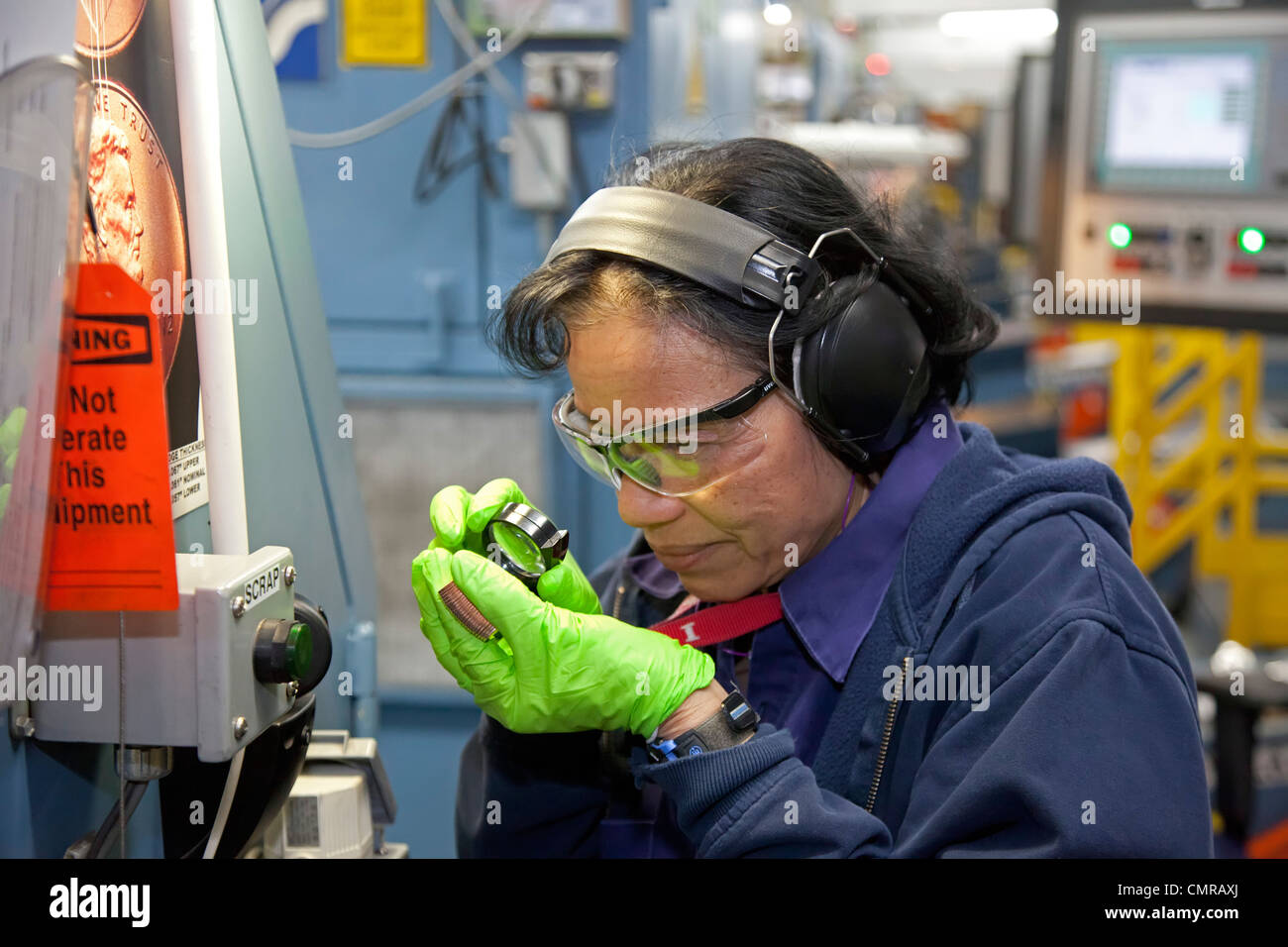 Denver, Colorado - un lavoratore ispeziona finito di penny monete presso la United States Mint. Foto Stock