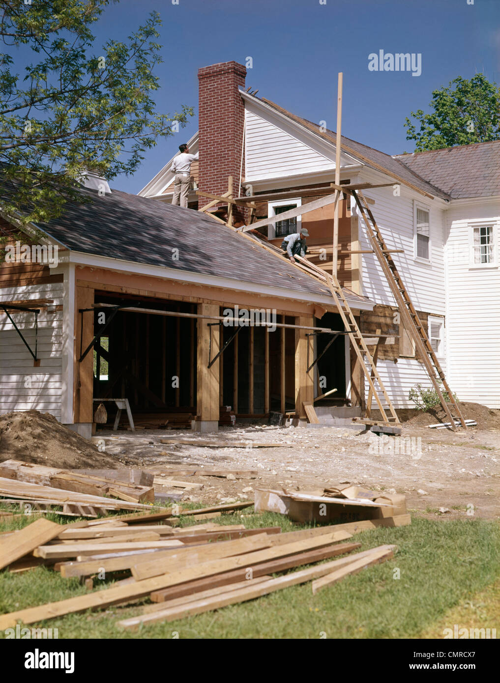 Anni sessanta anni settanta lavoratori la costruzione di due garage auto aggiunta sulla casa suburbana Foto Stock