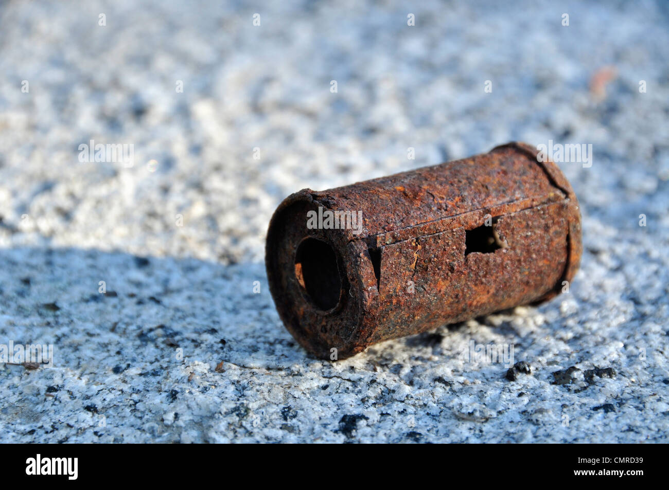 Vecchio arrugginito 35mm Pellicola canister sul masso di granito. Foto Stock