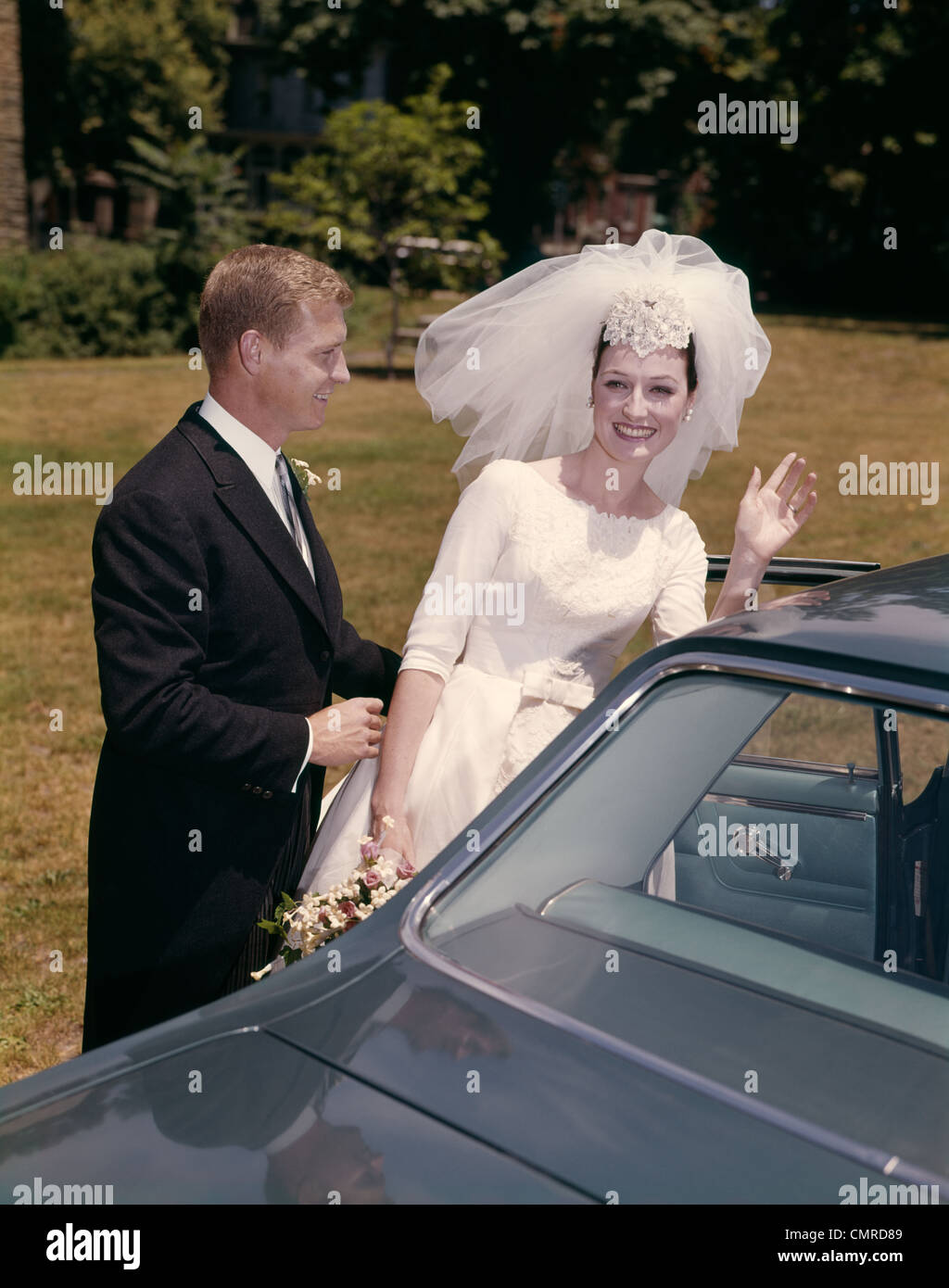Anni sessanta giovane sposa e lo sposo PER ARRIVARE IN AUTO DOPO IL MATRIMONIO Foto Stock
