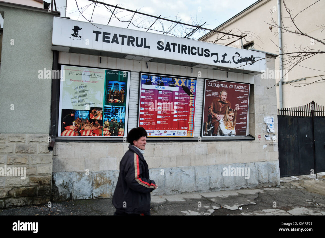 Local uomo a camminare in passato teatro di satira annuncio poster, Chisinau in Moldova - Marzo 2012 Foto Stock