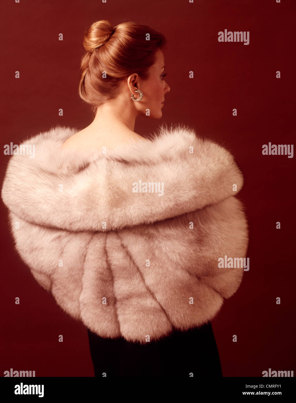 Anni Settanta eleganti donna elegante VISTA POSTERIORE INDOSSANDO SILVER stola di pelliccia cappotto Foto Stock