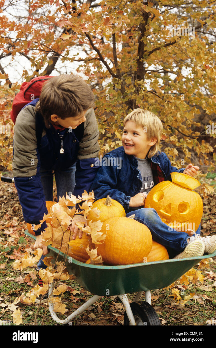 Anni ottanta due ragazzi con ruota BARROW e zucche di Halloween Foto Stock