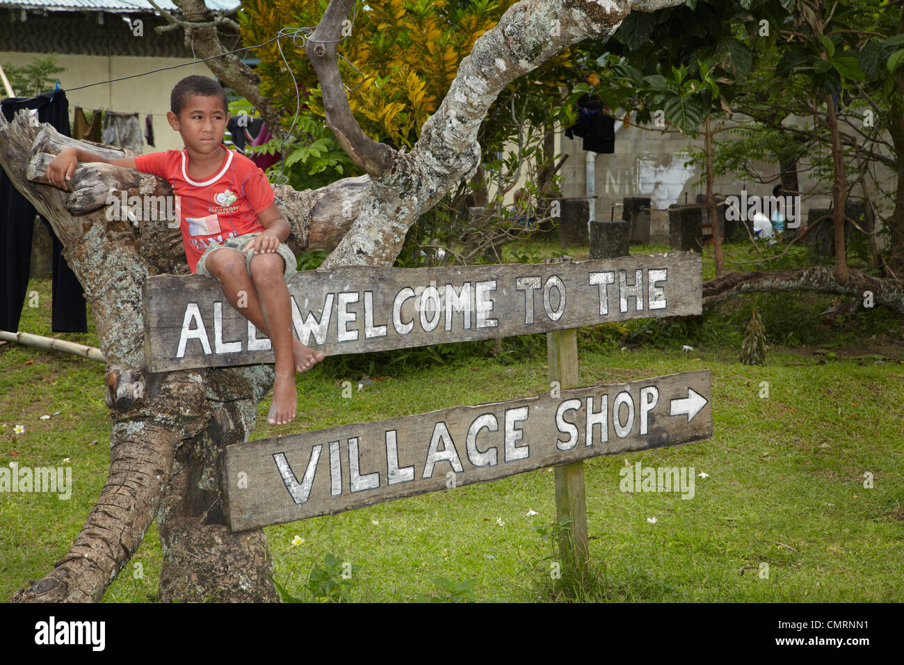 Ragazzo sul segno, Namaqumaqua village, il litorale di corallo, Viti Levu, Figi e Sud Pacifico Foto Stock