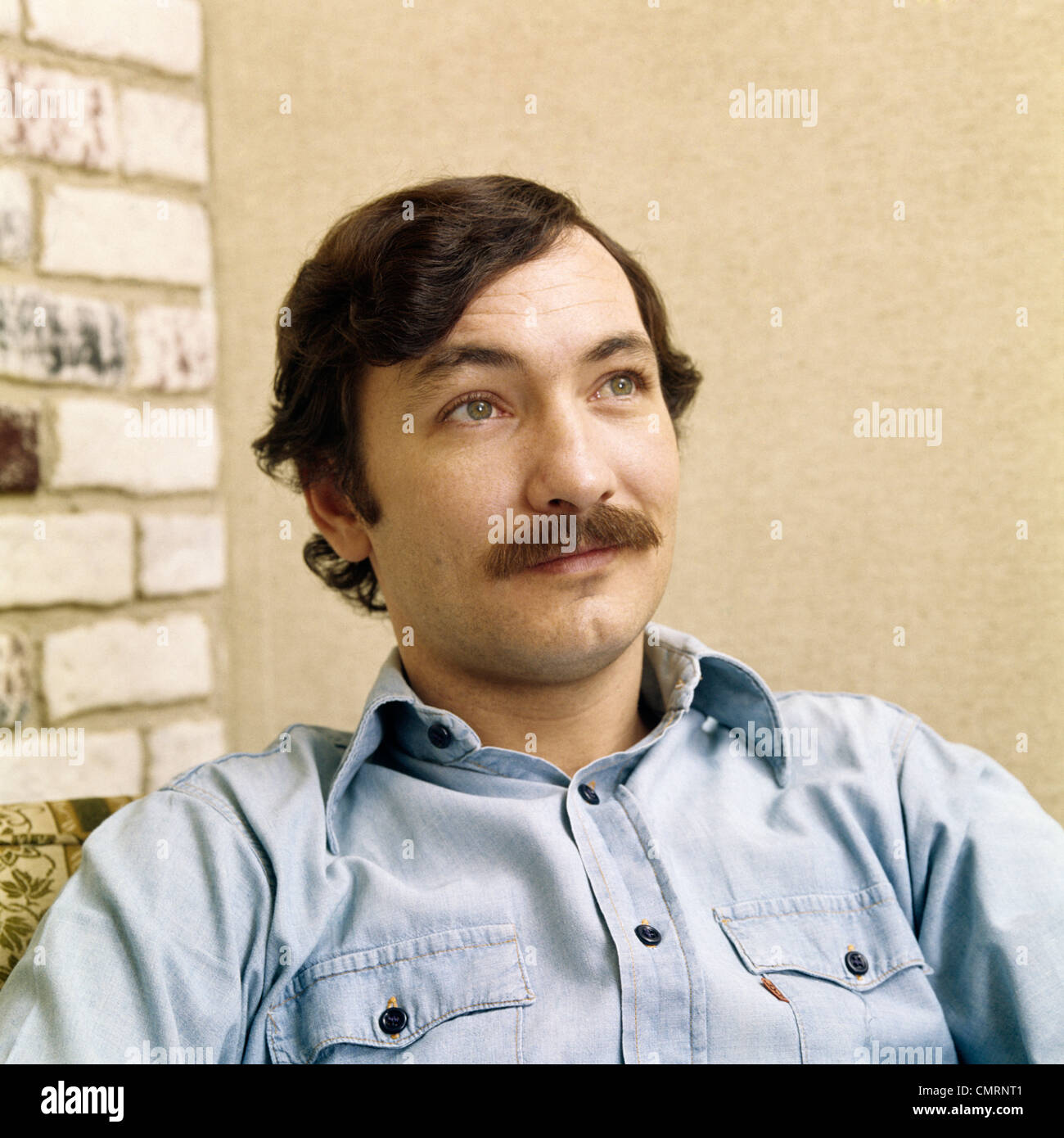 1970 anni settanta retrò uomo ritratto con capelli castani baffi indossando il denim SHIRT Foto Stock