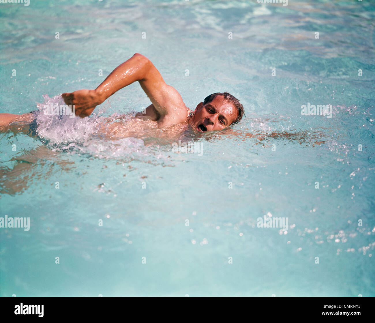 Anni sessanta UOMO IN ACQUA NUOTO CRAWL OVERHAND retrò di corsa Foto Stock
