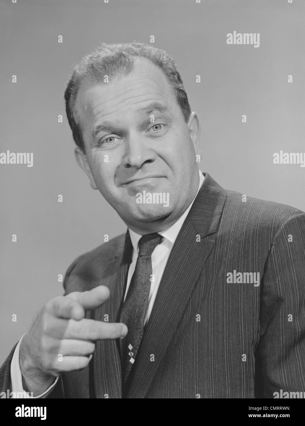 Anni Cinquanta anni sessanta ritratto uomo vestito che indossa cravatta sorridente puntare il dito guardando la fotocamera Foto Stock