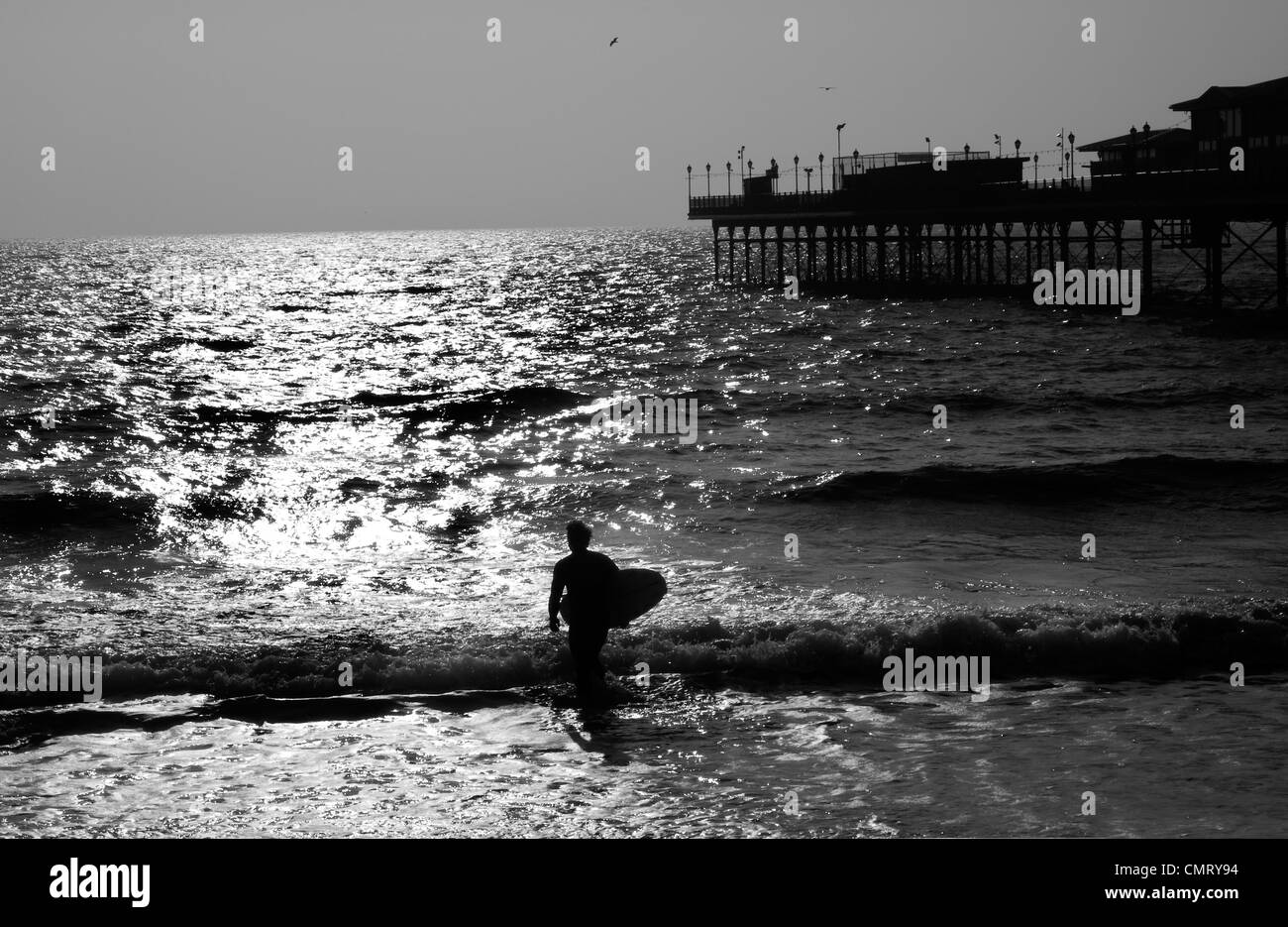 Staycation,surfer surf della costa del Devon,divertimento, spiaggia, edificio, devon, divertente, lampada, gambe, luce, Paignton, pier, Foto Stock