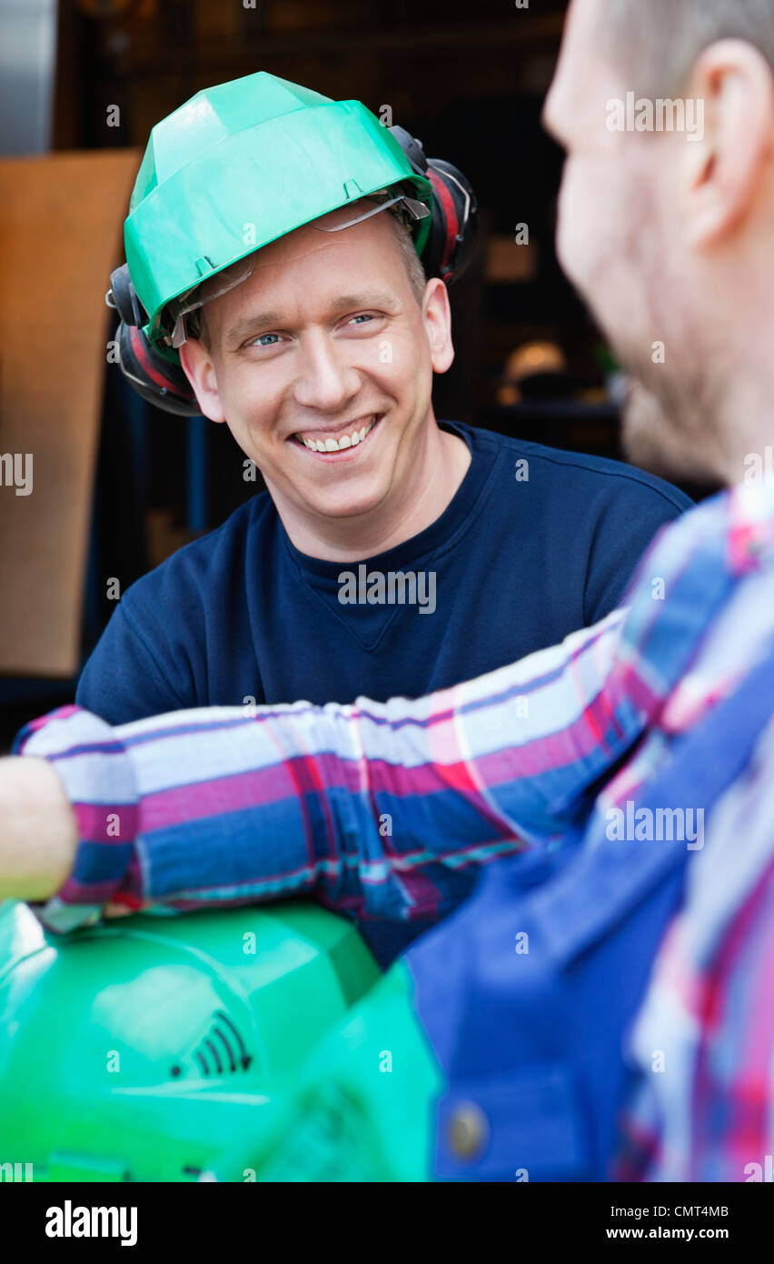 Due uomini con una sessione di conversazione testuale e di ridere Foto Stock