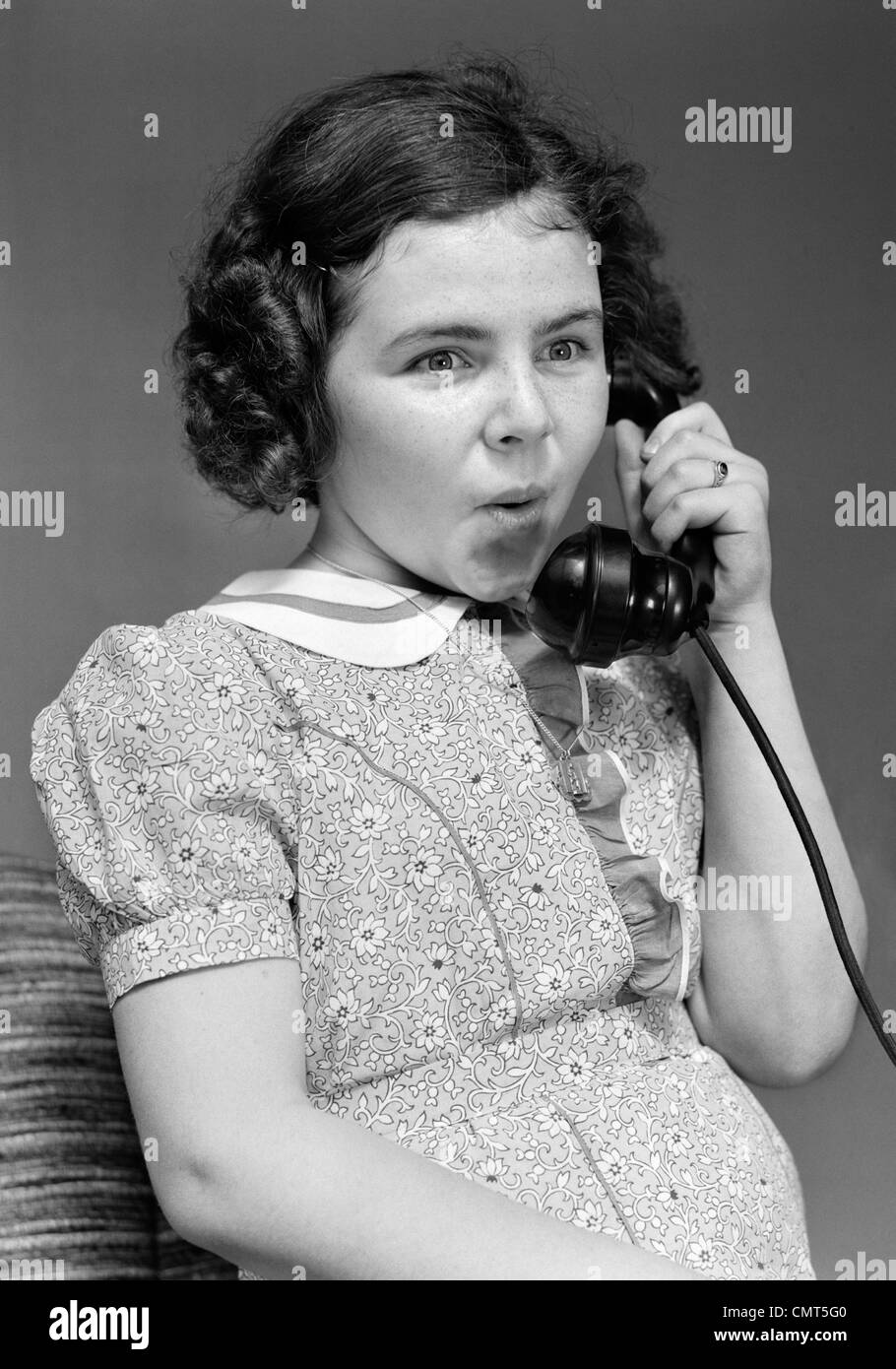 1930s ragazza parlando al telefono di espressione di sorpresa Foto Stock