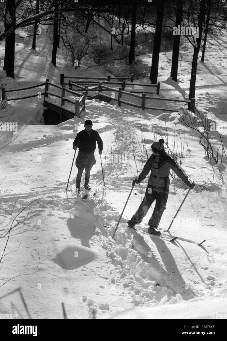 1930s GIOVANE UOMO E DONNA SCI CROSS COUNTRY nel bosco invernale sulla neve all'aperto Foto Stock