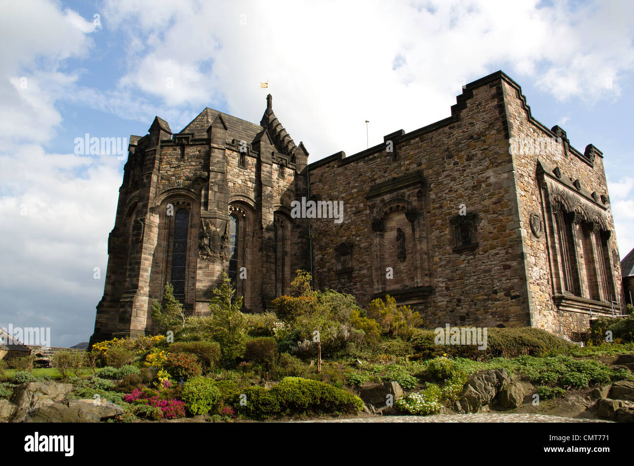 Edificio all interno del Castello di Edimburgo con le statue sulla parete e alcune vetrate, circondato dal verde e cielo molto nuvoloso Foto Stock