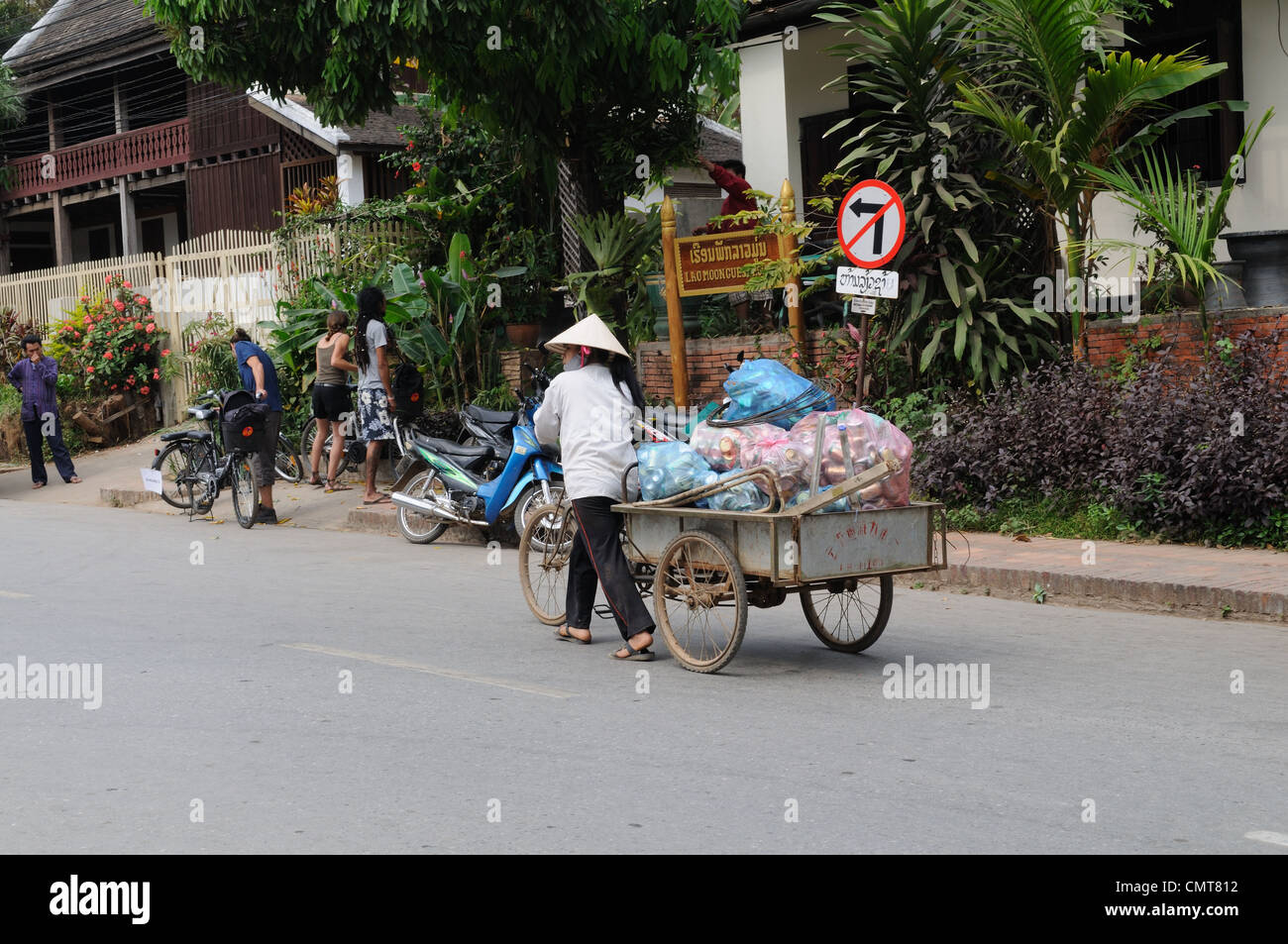 Lao donna utilizzando una bicicletta e carrello per raccogliere spazzatura Luang Prabang Laos Foto Stock