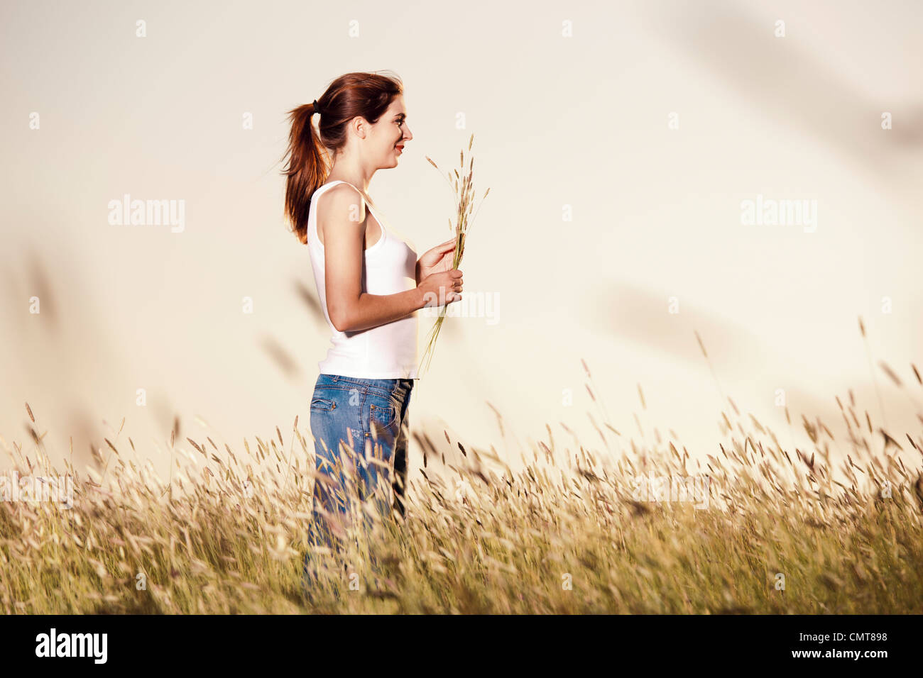 Outdoor ritratto di una donna bellissima azienda fiori su un giorno di estate Foto Stock