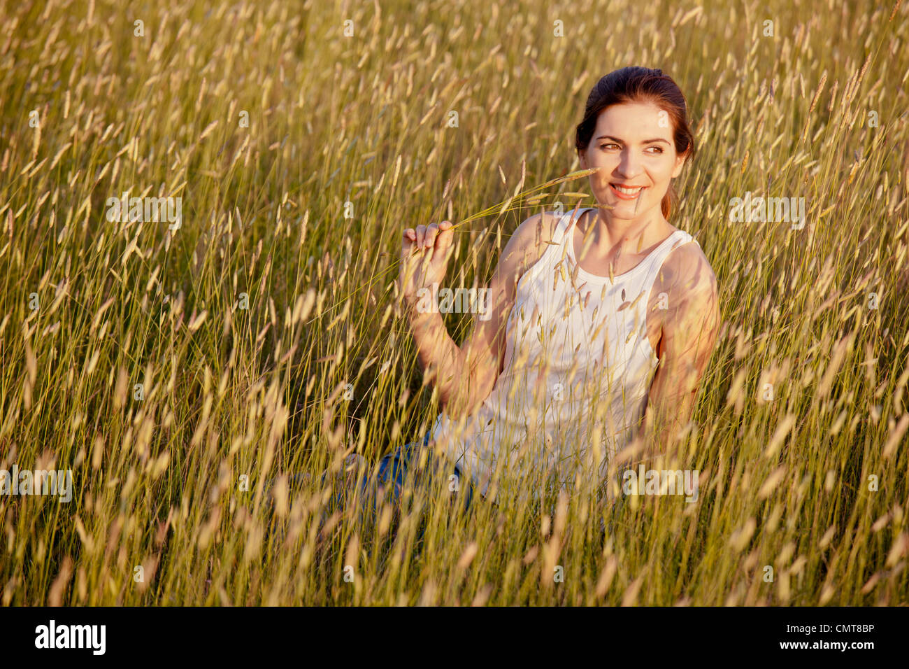 Outdoor ritratto di una donna bellissima azienda fiori su un giorno di estate Foto Stock