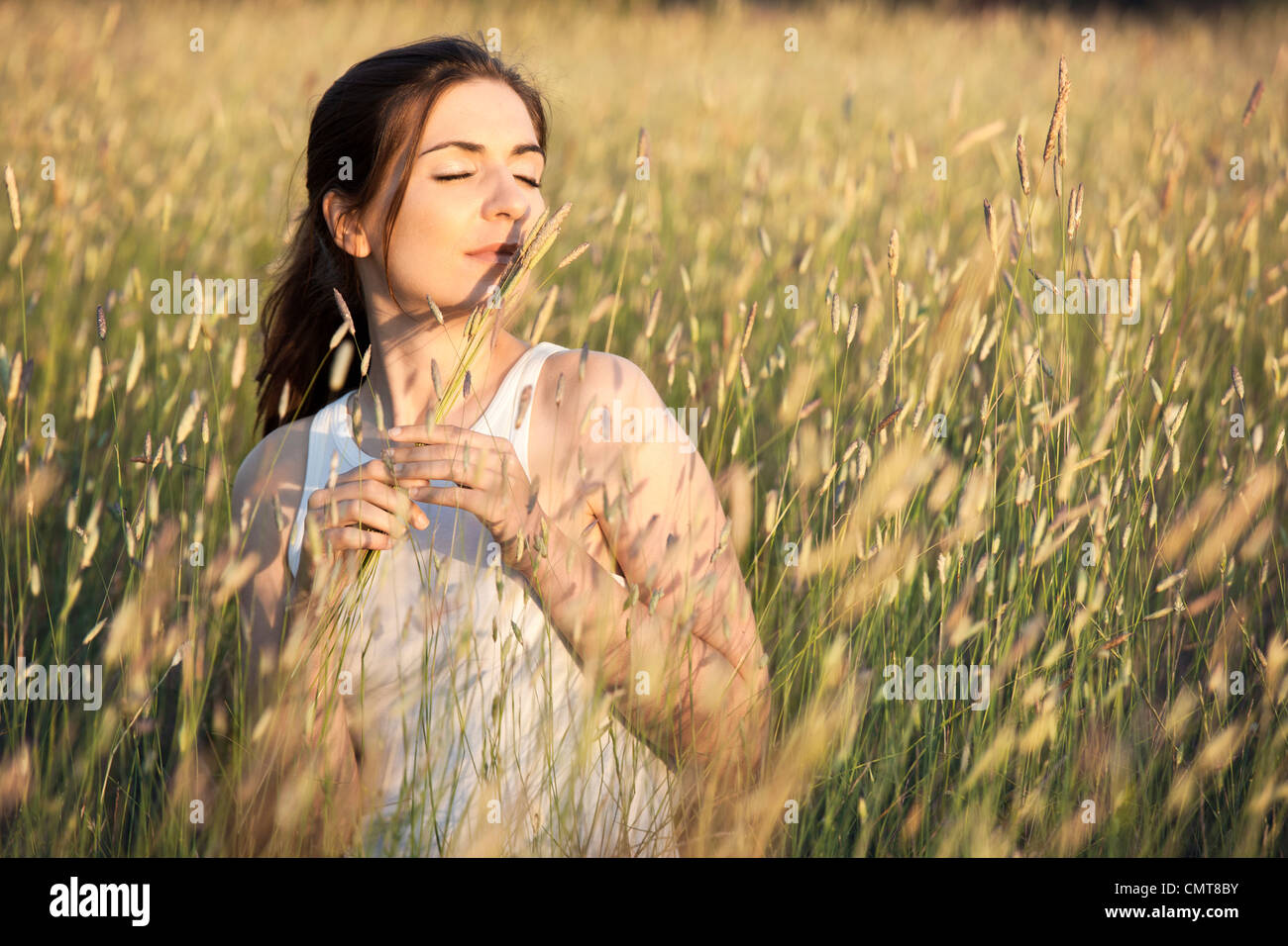 Outdoor ritratto di una donna bellissima profumati fiori su un giorno di estate Foto Stock