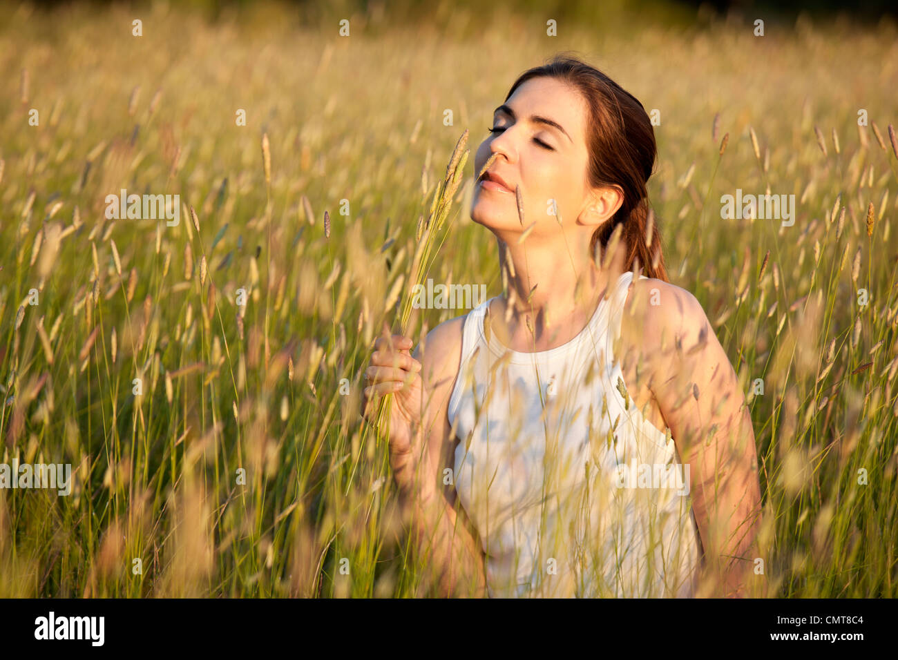 Outdoor ritratto di una donna bellissima profumati fiori su un giorno di estate Foto Stock