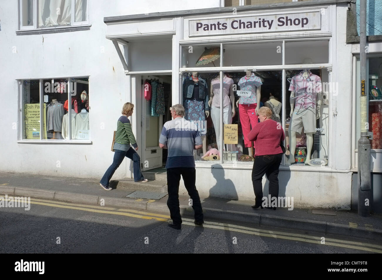 3 persone al di fuori della carità i pantaloni shop in Falmouth, Regno Unito. Pantalone è una carità raccolta fondi per gynecologigal & testicolari di conoscenza Foto Stock