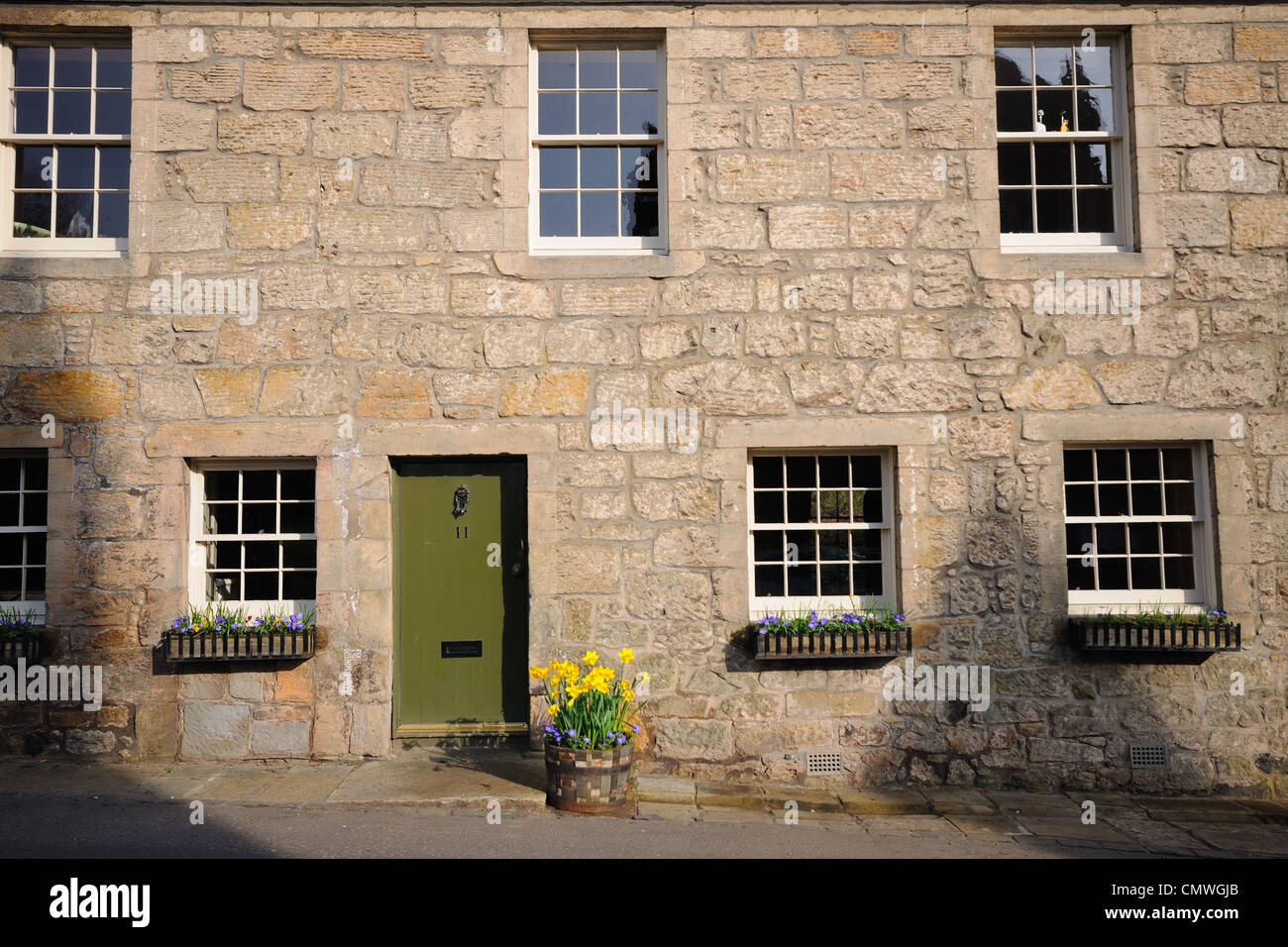 Una vecchia pietra costruito casa del villaggio di Kilbarchan nel Renfrewshire, Scozia, con il suo davanzale caselle e fiori. Foto Stock