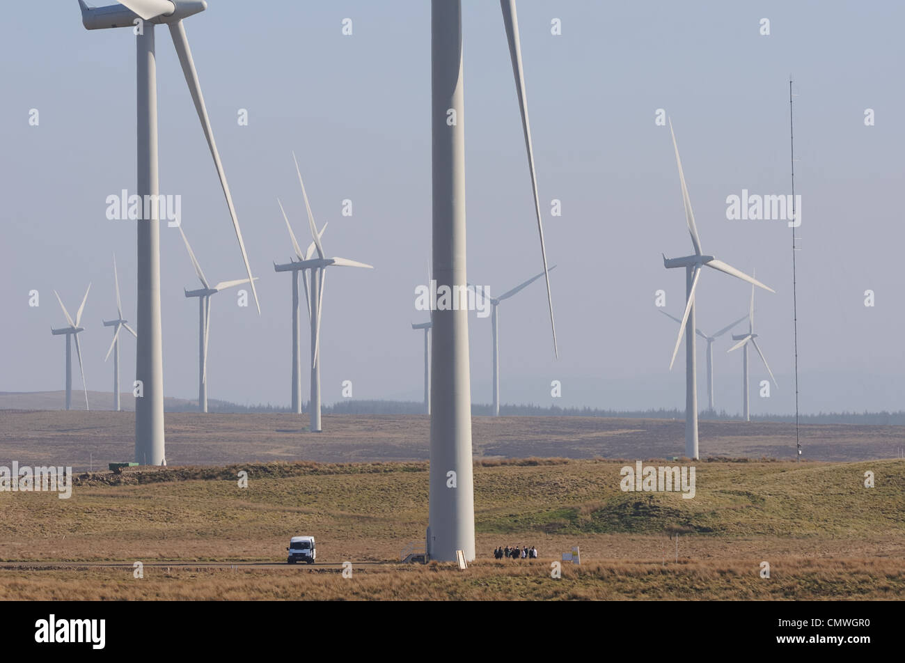 Immagine che mostra le dimensioni e la scala di turbine eoliche e farm. Vi  è un furgone e persone nella parte inferiore della prima turbina Foto stock  - Alamy