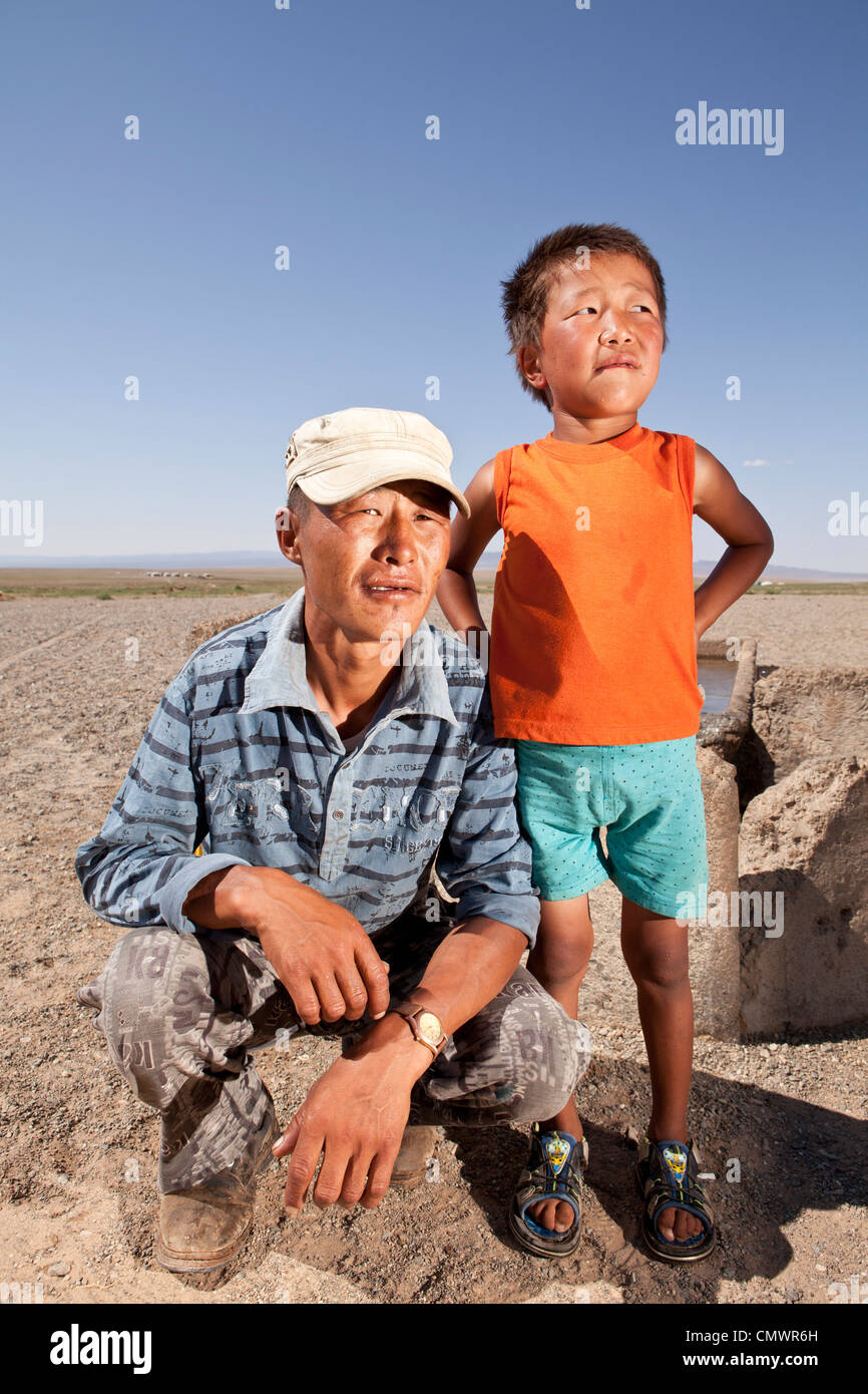 Padre e figlio si pongono di fronte all'oasi Gobi, Mongolia Foto Stock