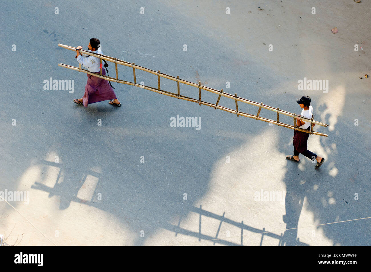 Due uomini che trasportano la scaletta in legno, Mandalay Myanmar Foto Stock