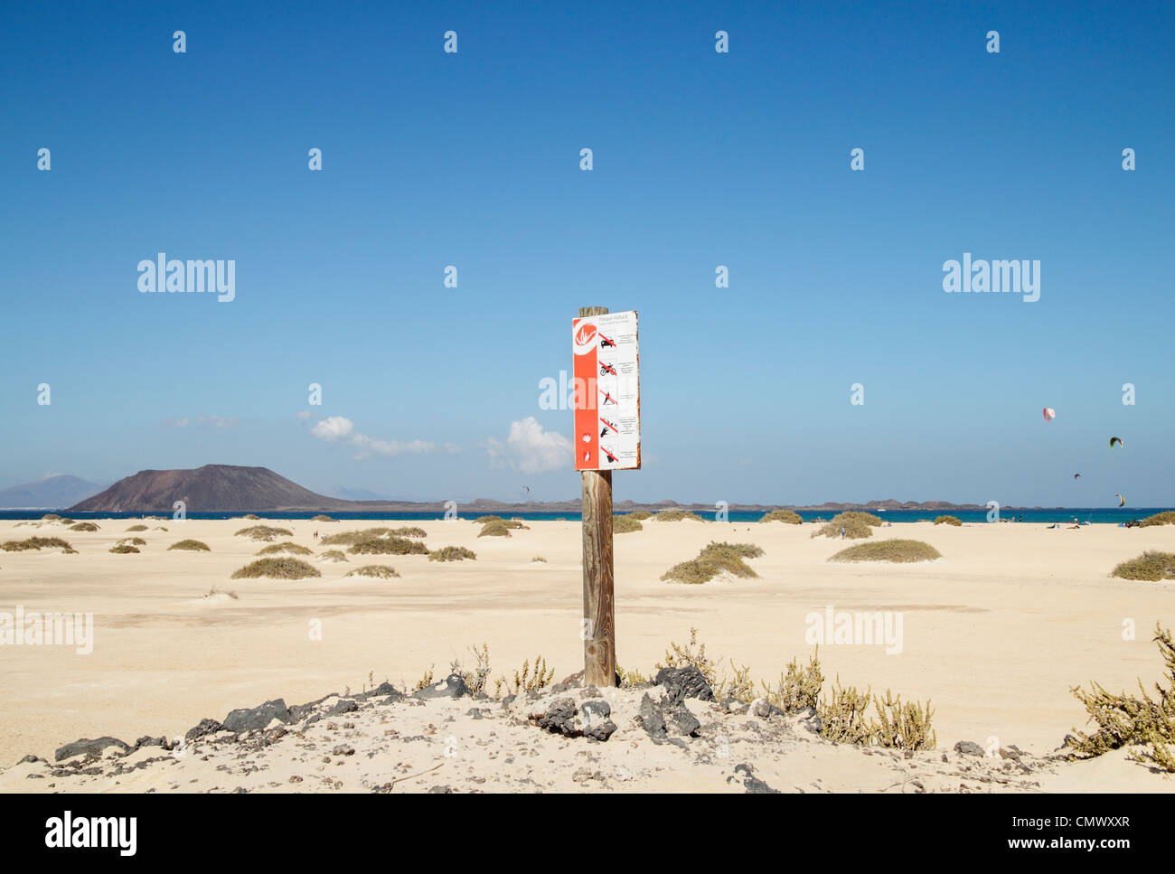 Parque Natural de Las Dunas de Corralejo segno con isola di Lobos e kitesurfisti in distanza. Fuerteventura Isole Canarie Foto Stock
