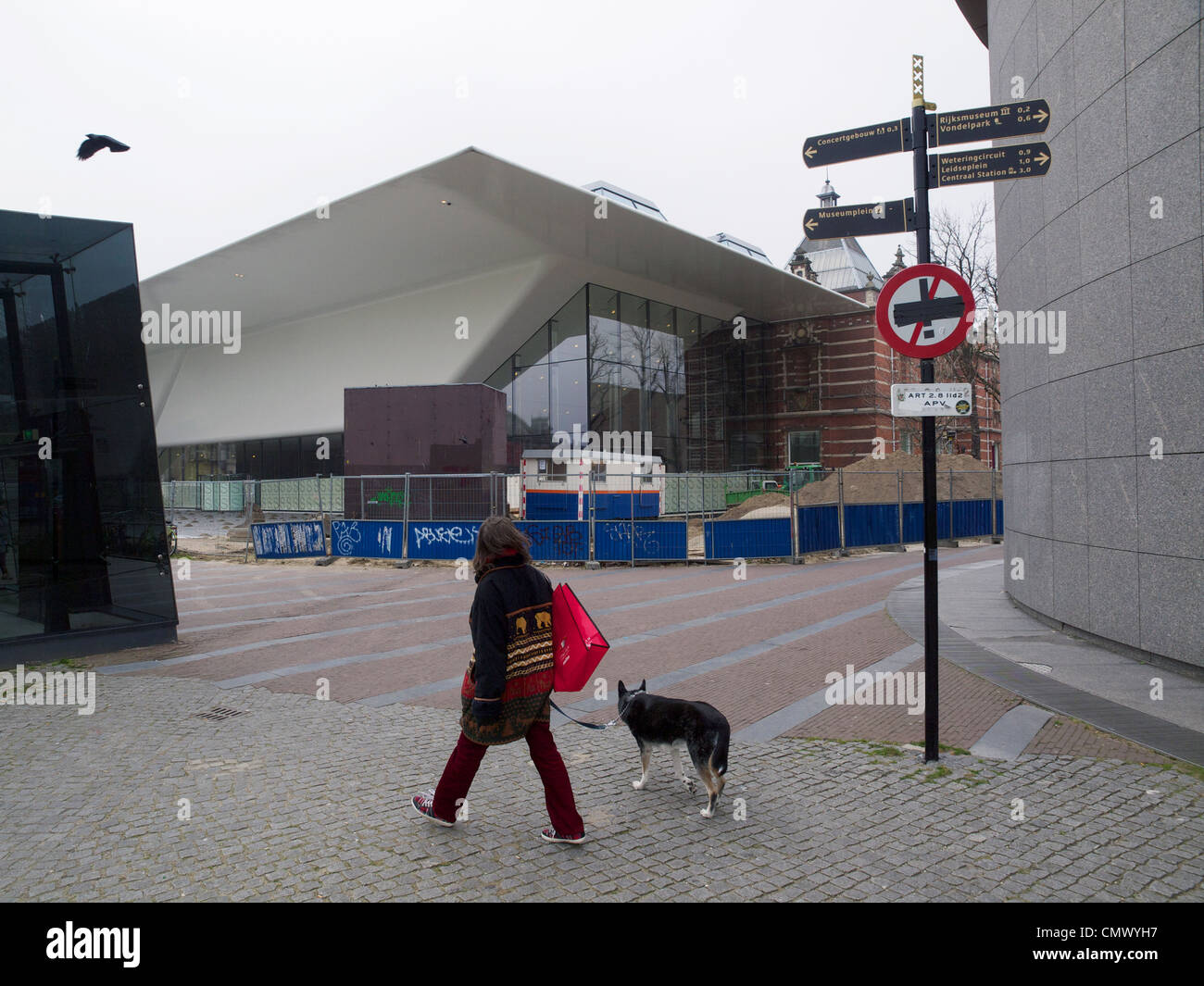 Donna con il suo cane a camminare sul Museumplein piazza davanti al nuovo controverso Stedelijk Museum espansione in Amsterdam Foto Stock