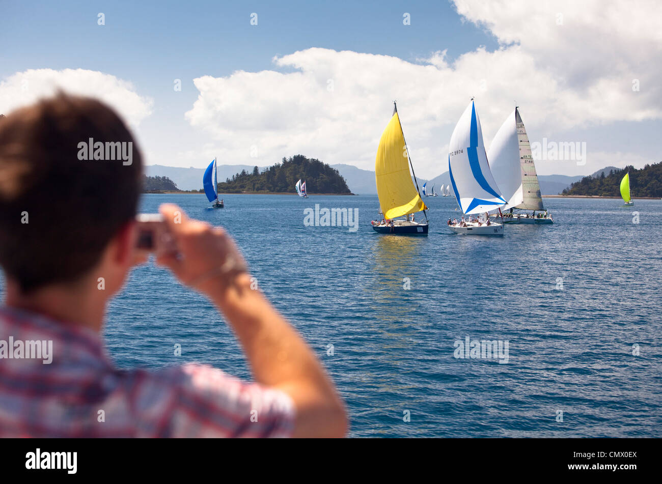 Uomo di fotografare yachts racing durante Hamilton Island Race Week. Whitsundays, Queensland, Australia Foto Stock
