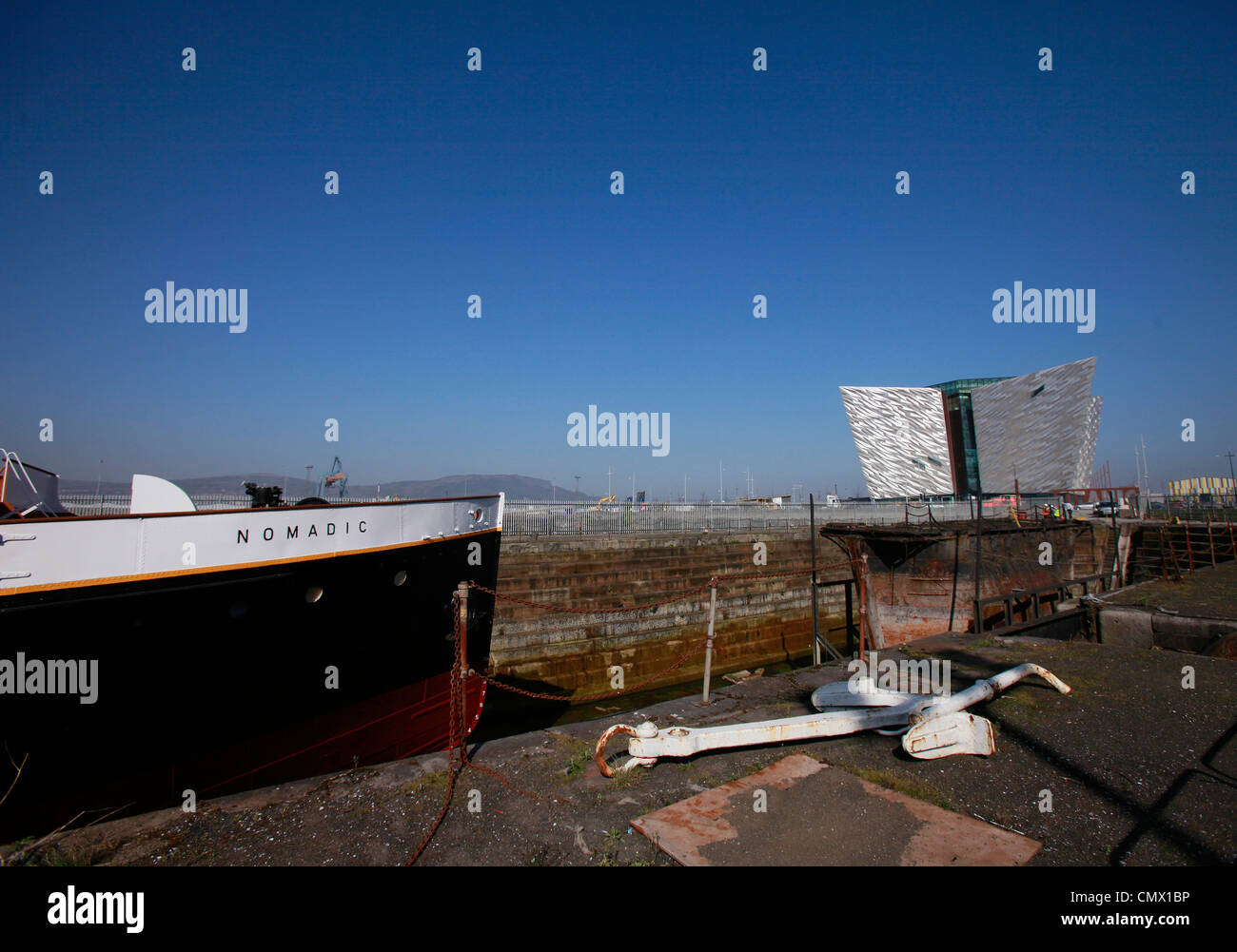 La nave nomadi si siede nel bacino di carenaggio con il Titanic Visitor Centre in background in Belfast, Irlanda del Nord Foto Stock