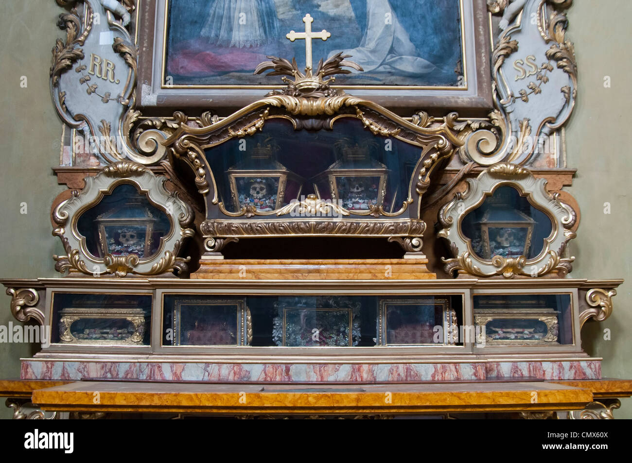 Santo / sacerdote rimane in ornato di vetro frontale in casi in una chiesa cattolica a Bergamo Foto Stock