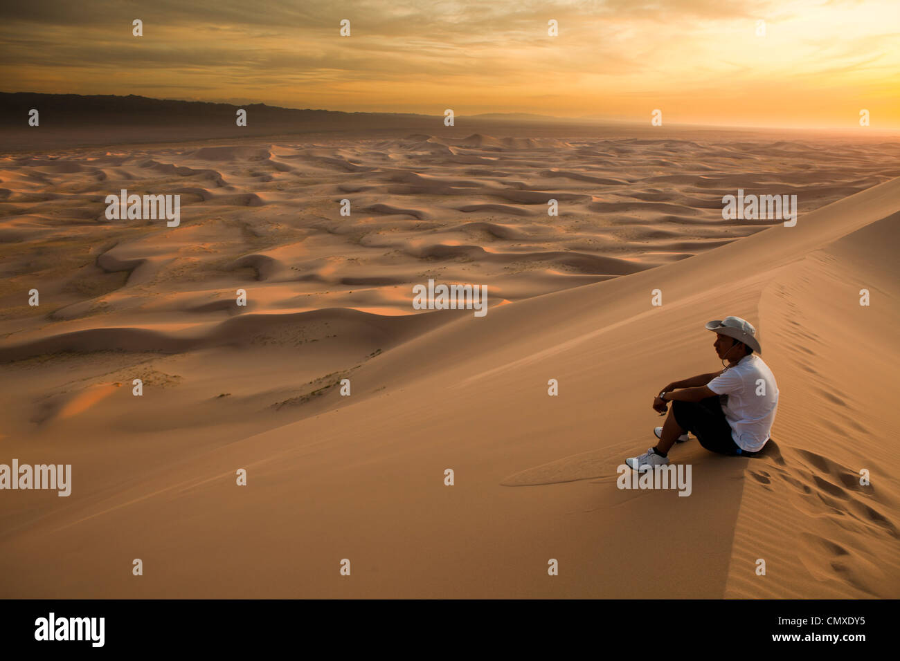 L'uomo sedersi sul Khongor duna di sabbia, deserto dei Gobi e Mongolia Foto Stock