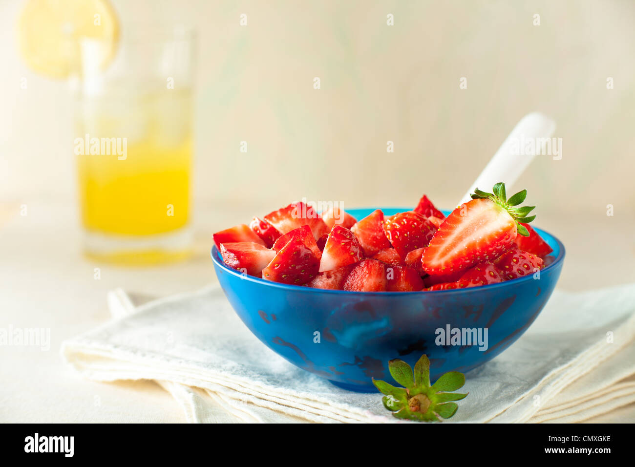 Fragola insalata di frutta in una ciotola blu con limonata Foto Stock