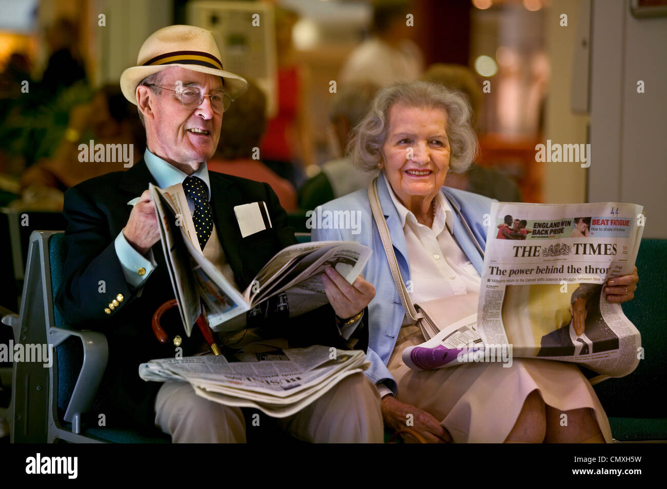 Coppia di anziani in attesa della partenza lounge presso l'aeroporto di Heathrow Foto Stock