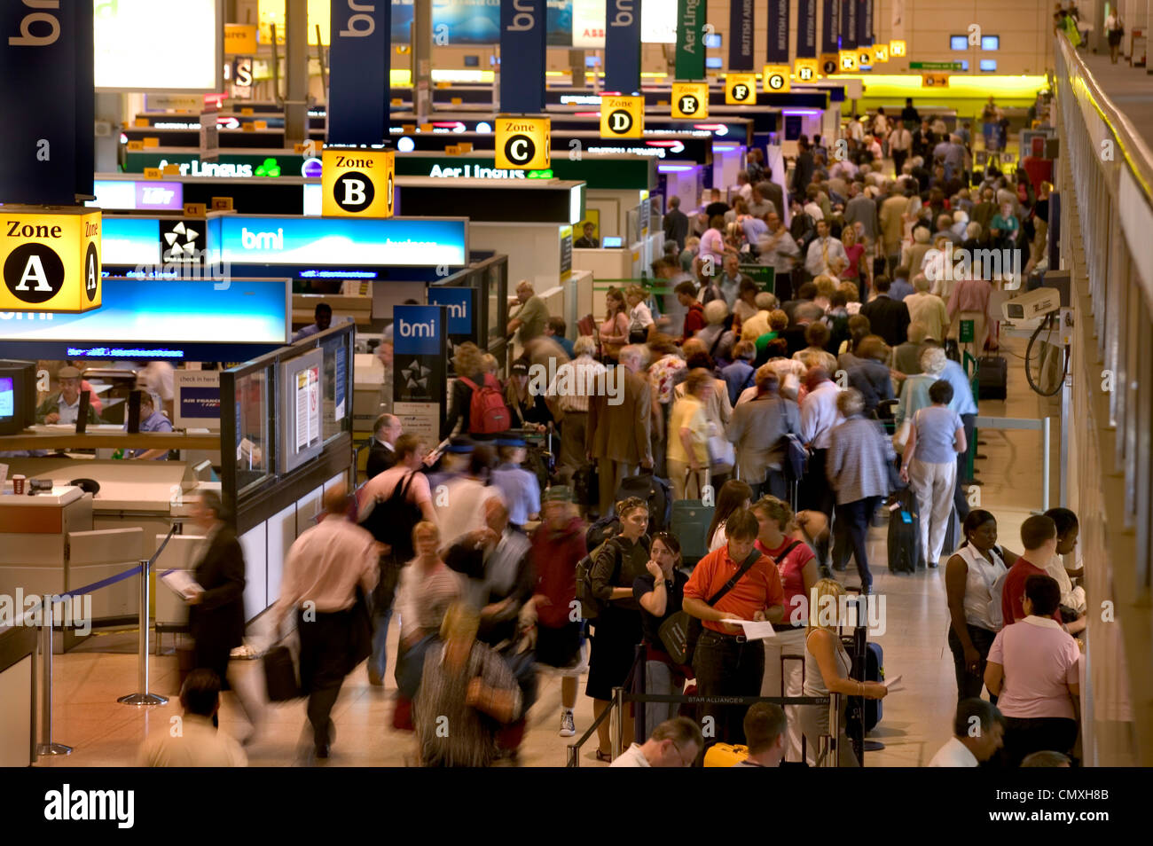 Banchi per il check-in in partenza occupato lounge presso l'aeroporto di Heathrow Foto Stock