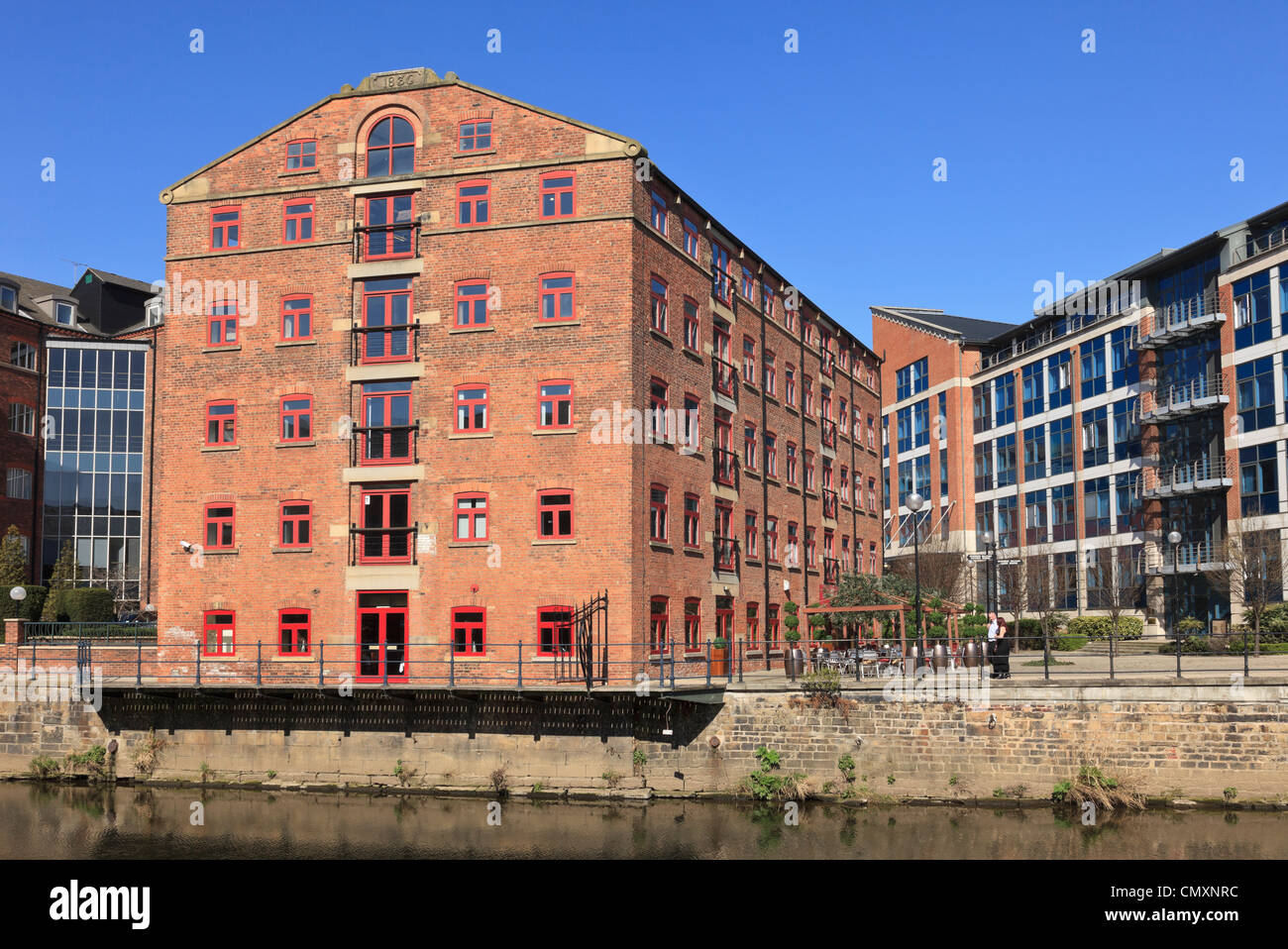 Leeds, West Yorkshire, Inghilterra, Regno Unito. Vecchi edifici industriali e moderni appartamenti sul molo ristrutturato dal fiume Aire Foto Stock