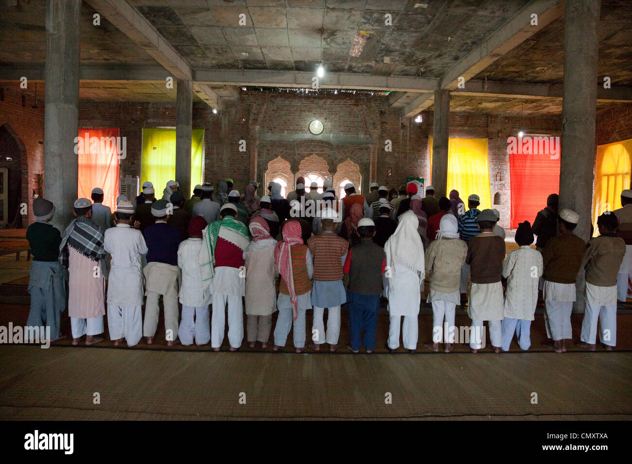 Congregazione assemblata per metà giornata di preghiera in moschea in costruzione, Madrasa Islamia saudita Izharul-Uloom, Dehradun, India. Foto Stock