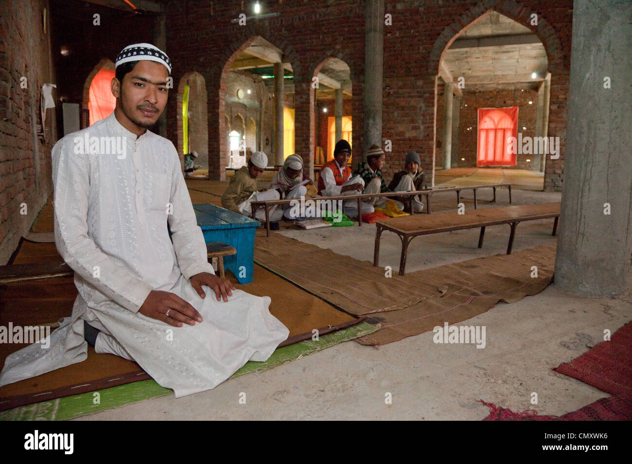 Madrasa gli studenti con i loro imam, all'interno della moschea in costruzione. Madrasa Islamia saudita Izharul-Uloom, Dehradun, India. Foto Stock