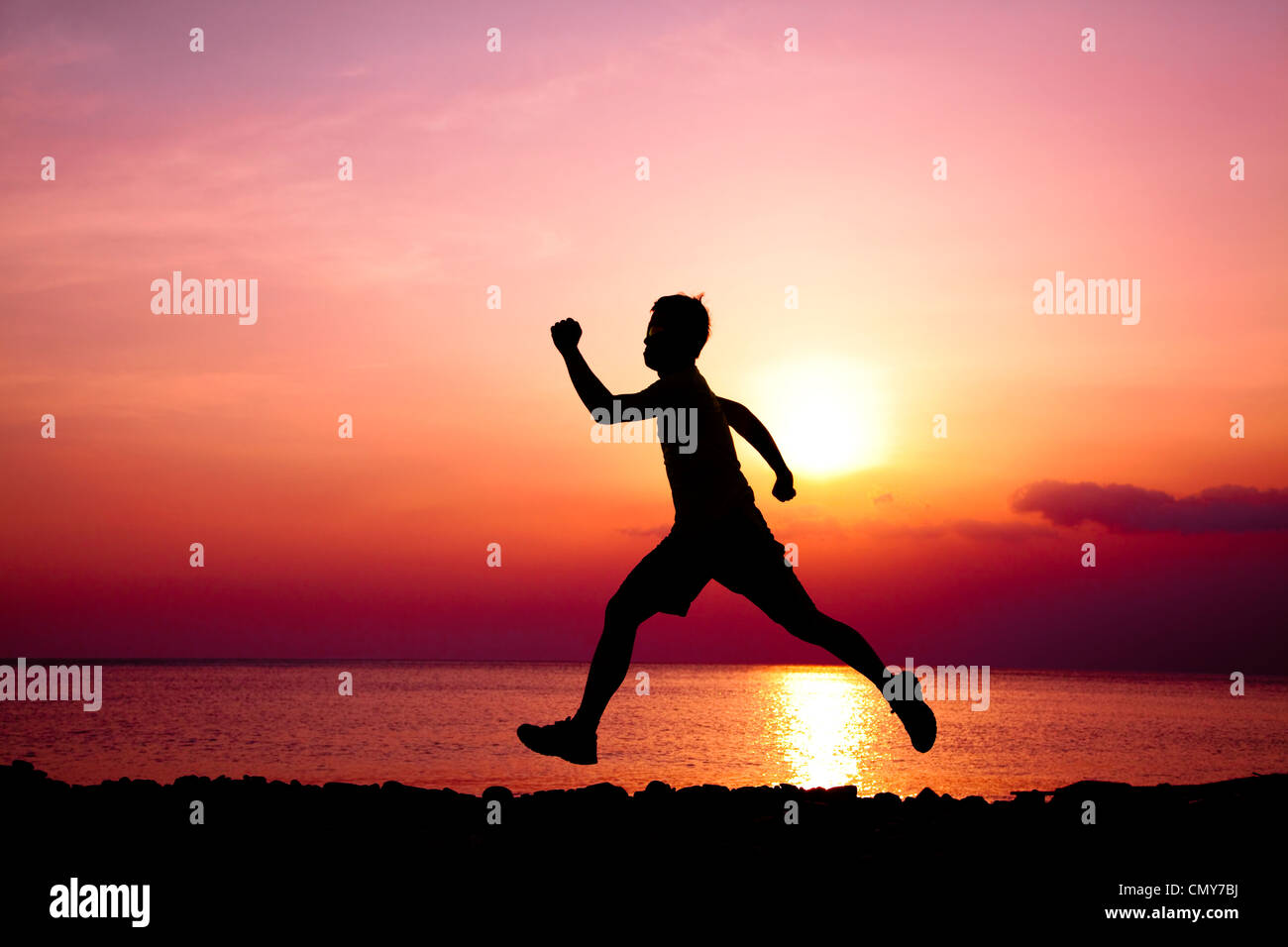 La silhouette di un runner sulla spiaggia Foto Stock