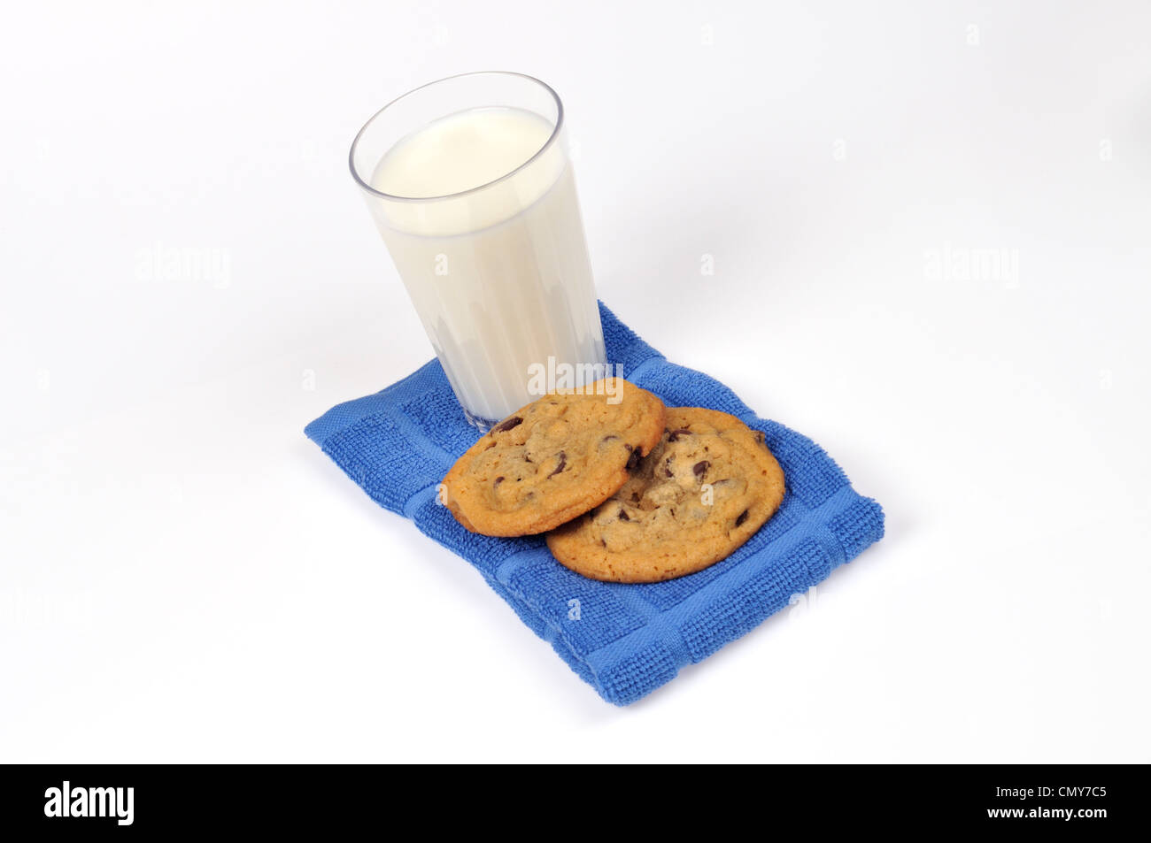 Chocolate Chip coolies e un bicchiere di latte sul tovagliolo blu su sfondo bianco USA Foto Stock