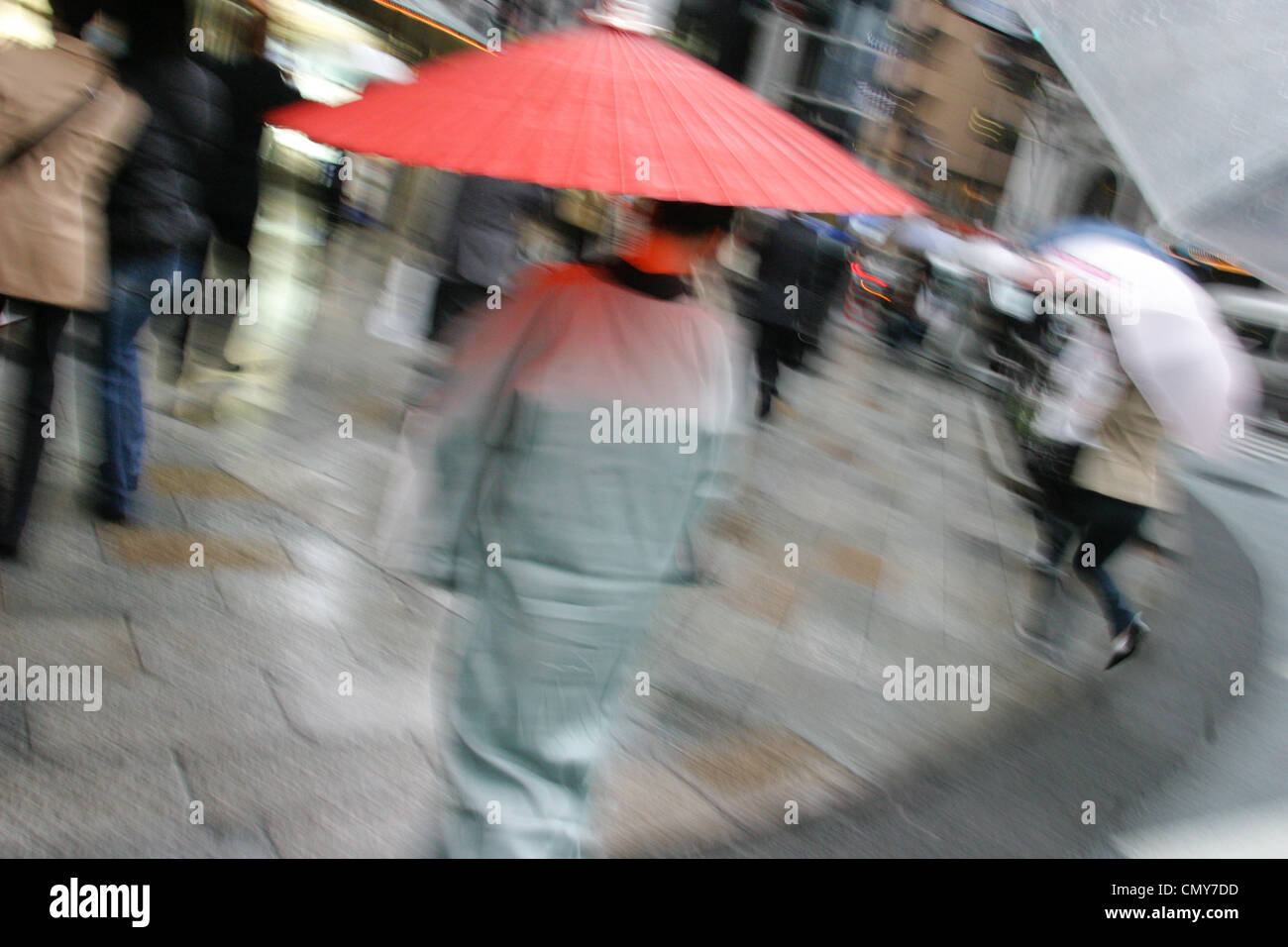 Donna giapponese di indossare il kimono e portante un ombrellone rosso, passeggiate in strada. In Giappone. Foto Stock