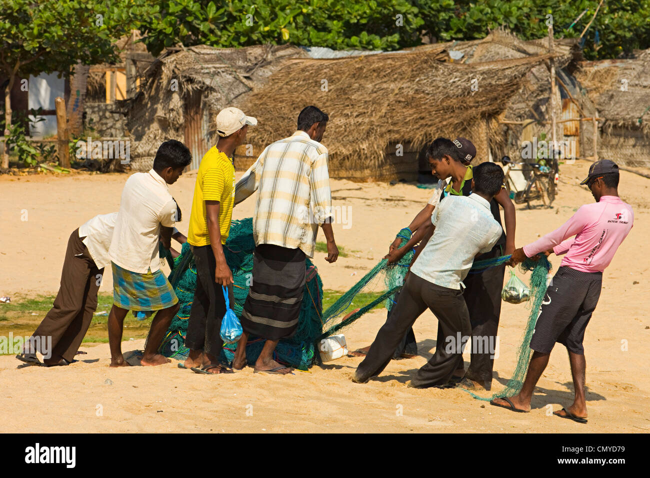I pescatori tirando le reti in questo popolare spiaggia per il surf che è stata colpita dallo tsunami; Arugam Bay, Provincia Orientale, Sri Lanka Foto Stock