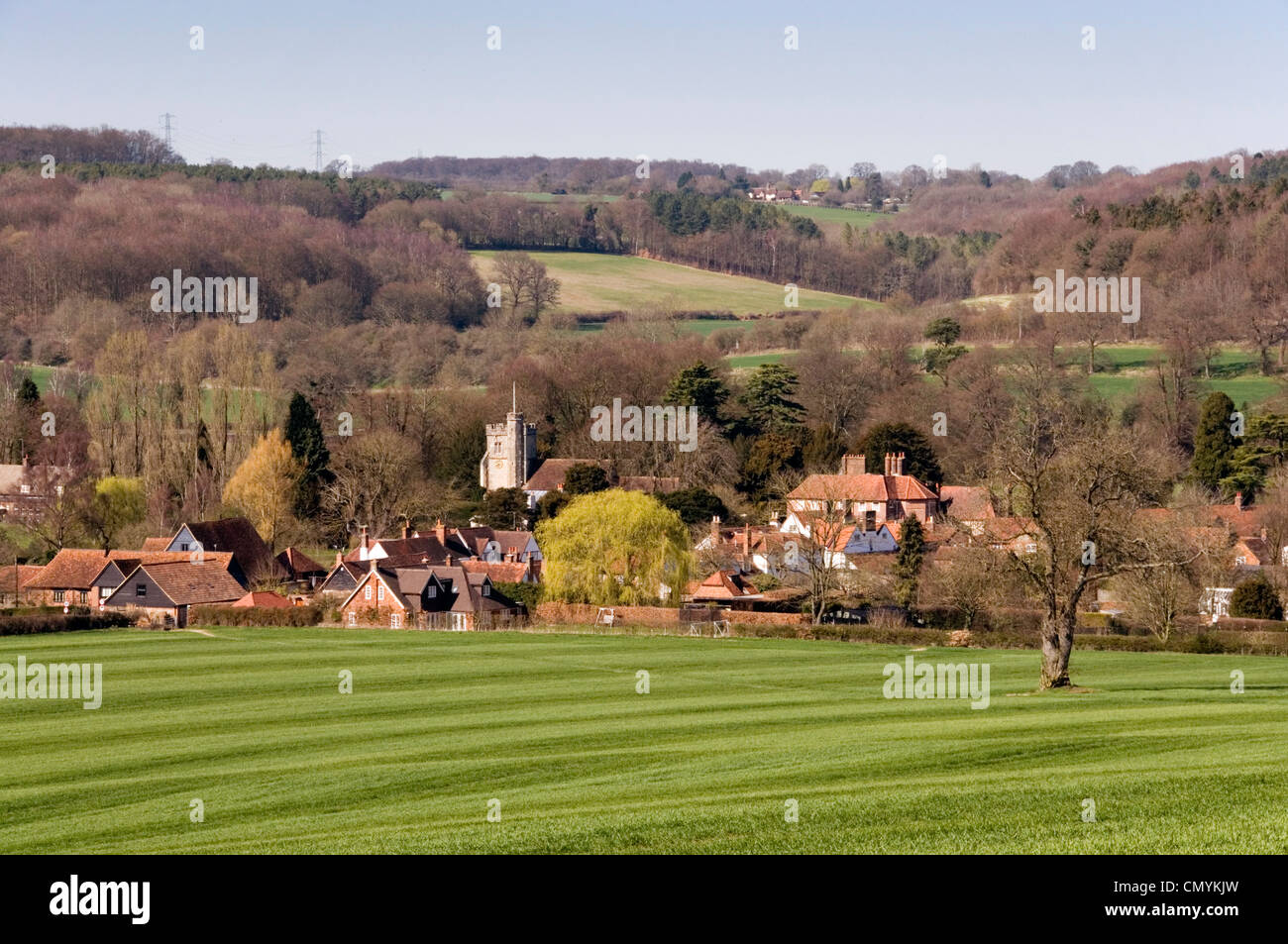 Chiltern Hills - Visualizza Little Missenden village - attraverso il campo verde del frumento primaverile - contrassegnata come un fresco prato - sole di primavera Foto Stock